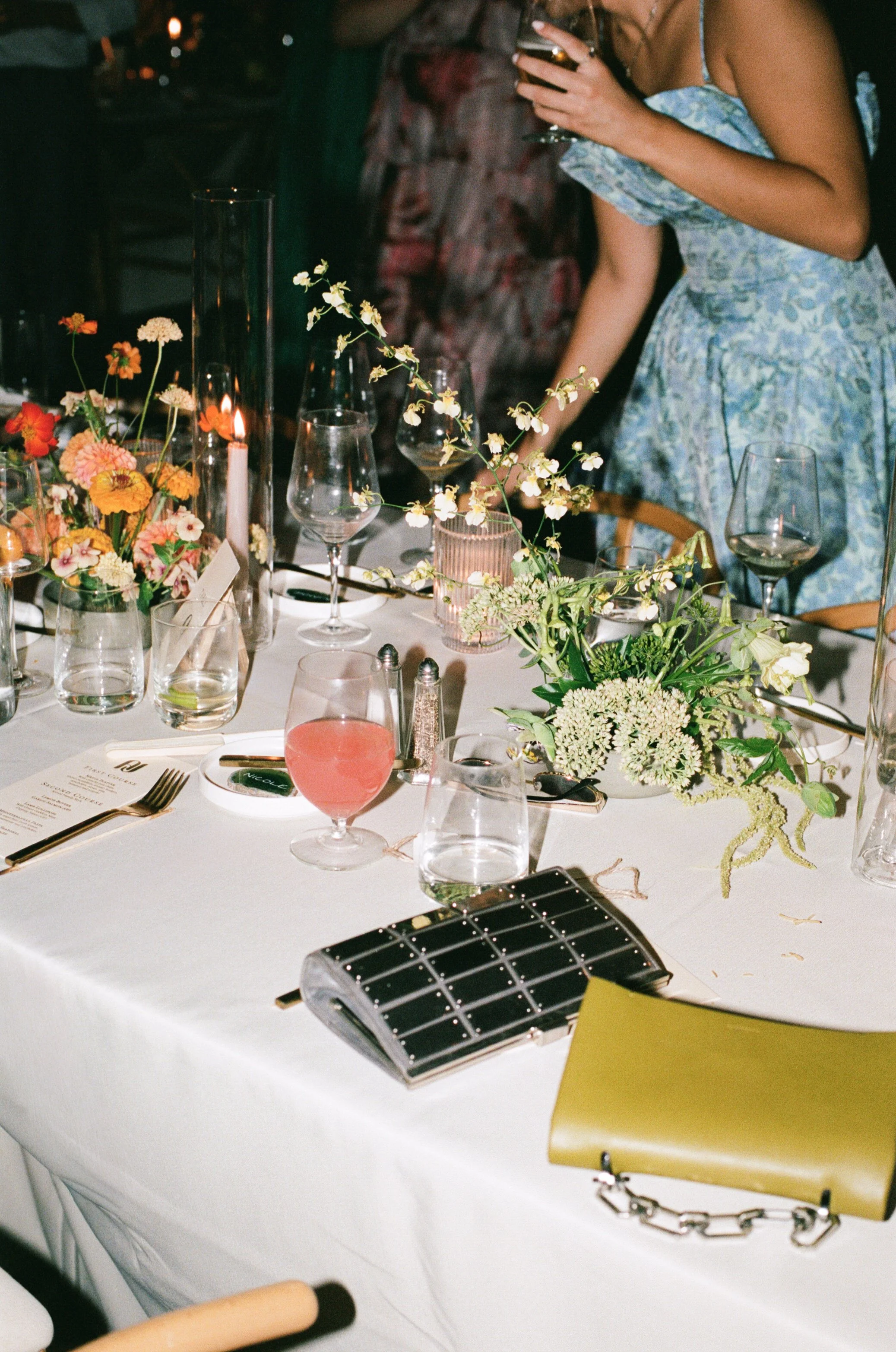  120mm film detail shot of reception tablescape with colorful floral arrangements 