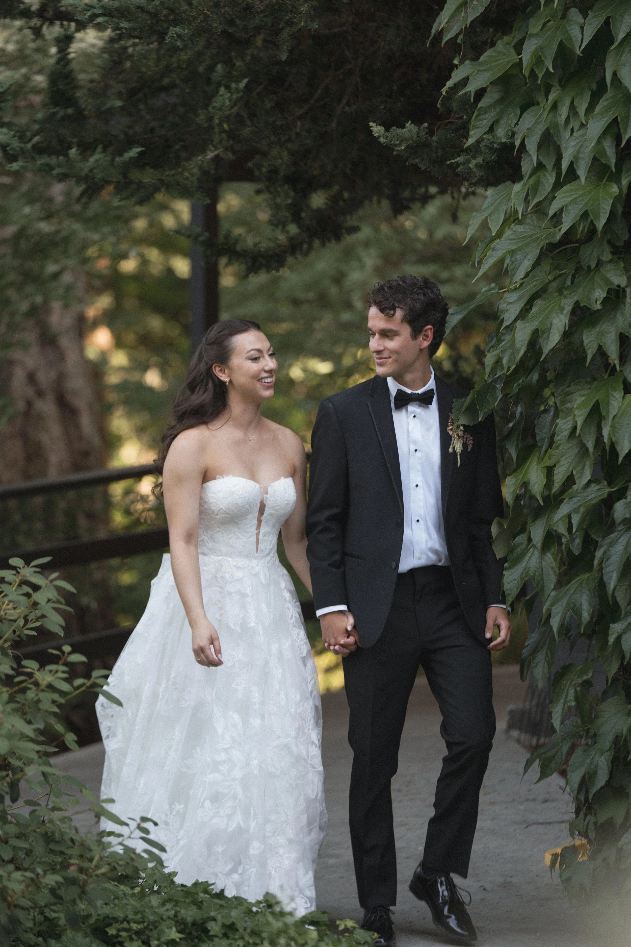  Bride and groom walking through the lush gardens at JM Cellars during their romantic summer wedding in Washington 