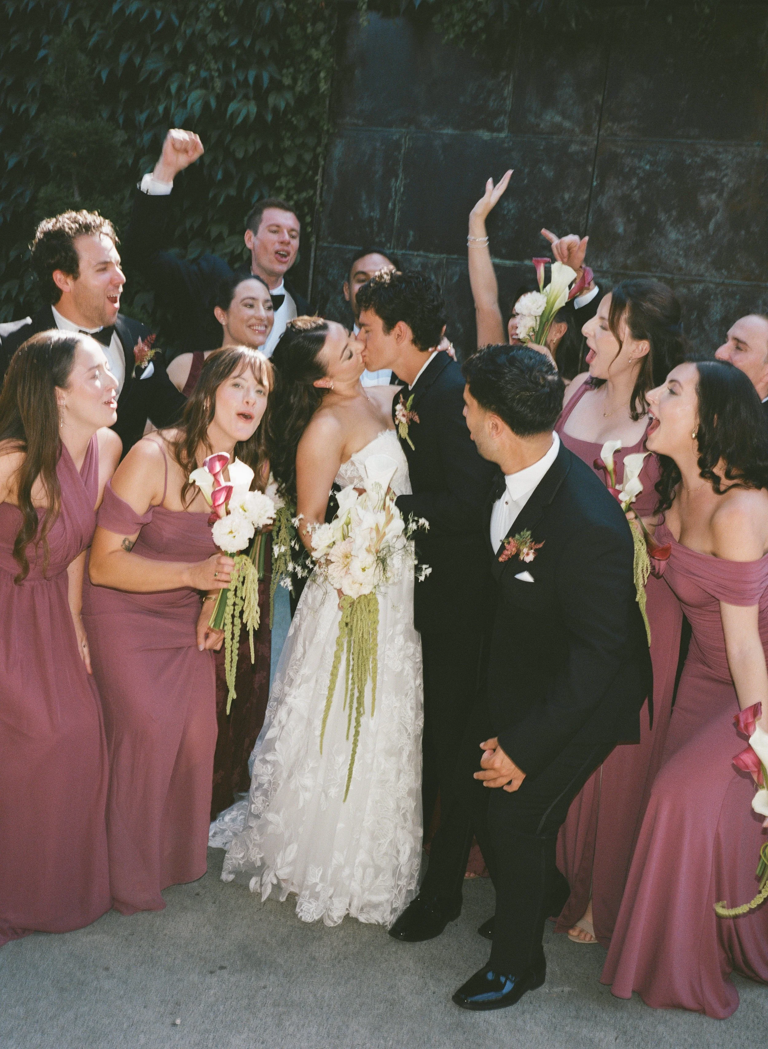  Film wedding photography at JM Cellars capturing a romantic outdoor celebration surrounded by trees and ivy. Wedding part celebrating group portrait. 