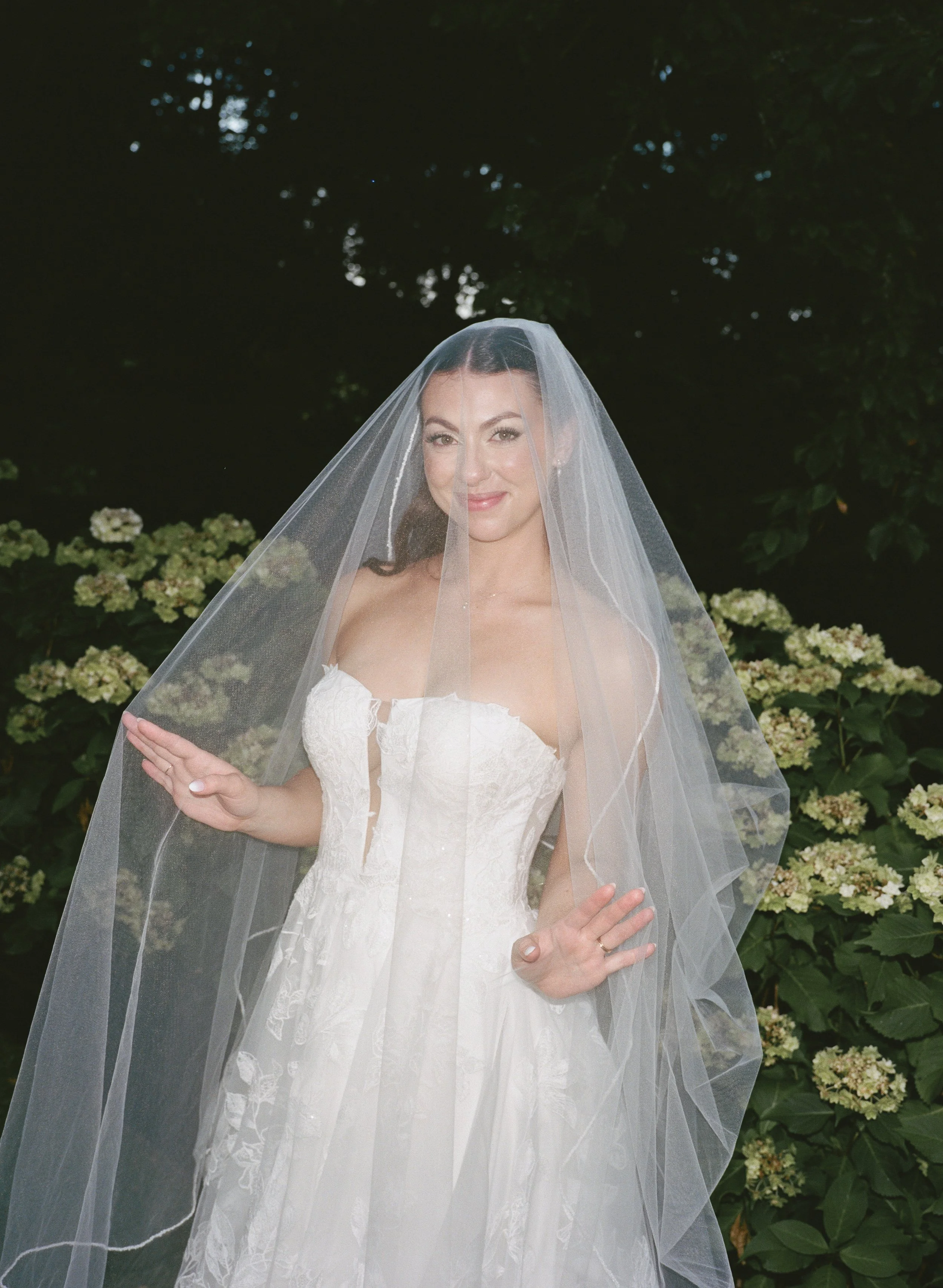  Film wedding photography at JM Cellars capturing a romantic outdoor celebration surrounded by trees and ivy. Bridal portrait under veil captured on film 
