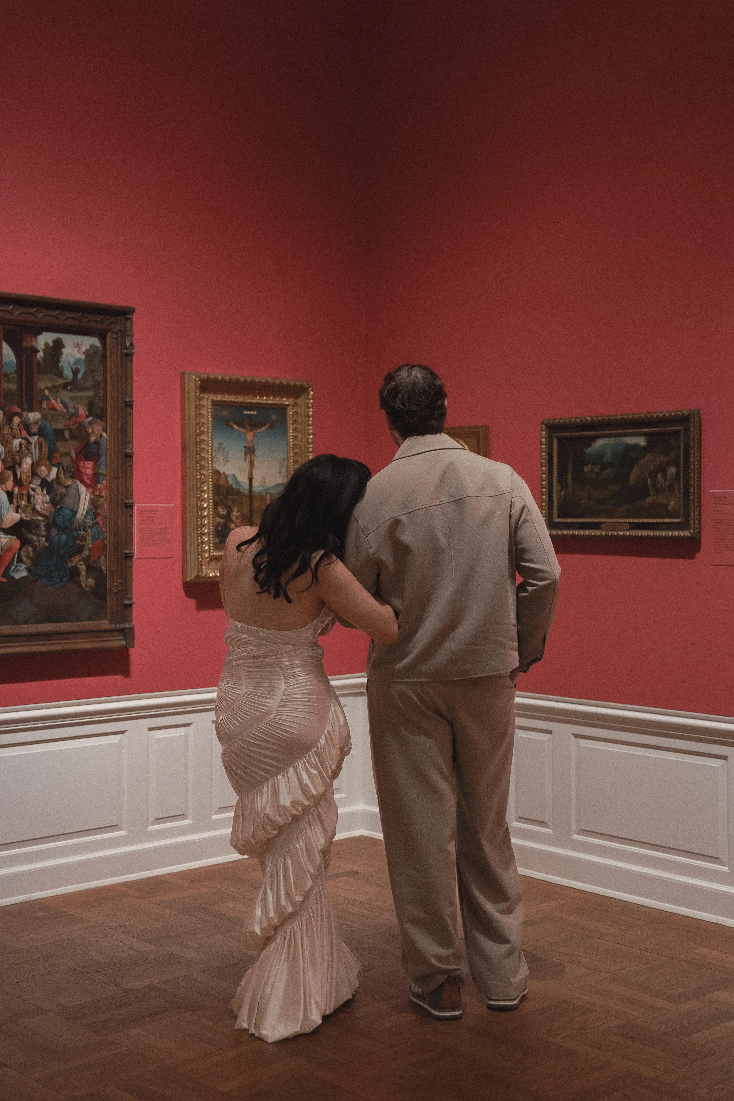 Couple sharing a quiet moment surrounded by artwork at the Portland Art Museum, documentary style engagement photography, shot on film