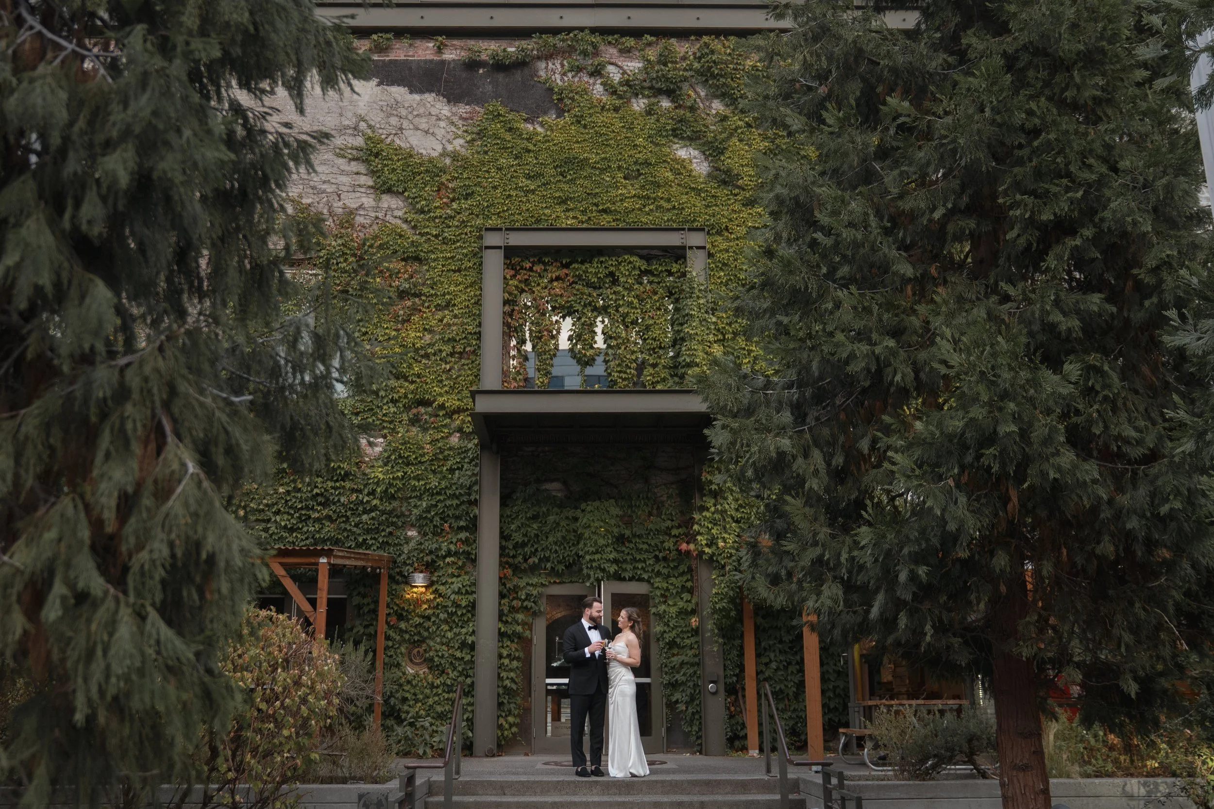 Bride and groom portrait in front of a large lush ivy wall in downtown portland