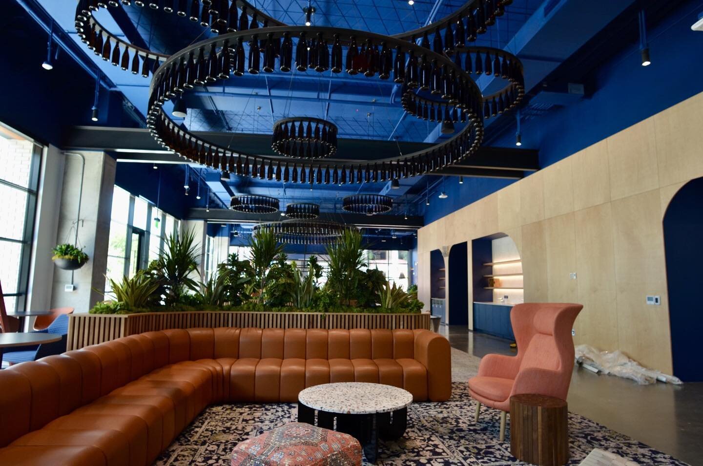 Atlassian austin lobby - the bottle features hang from steel cables bringing the space down to a more human scale, accented by faux beams that give the impression of substantial structure. designed by Mithun construction by Harvey Cleary
