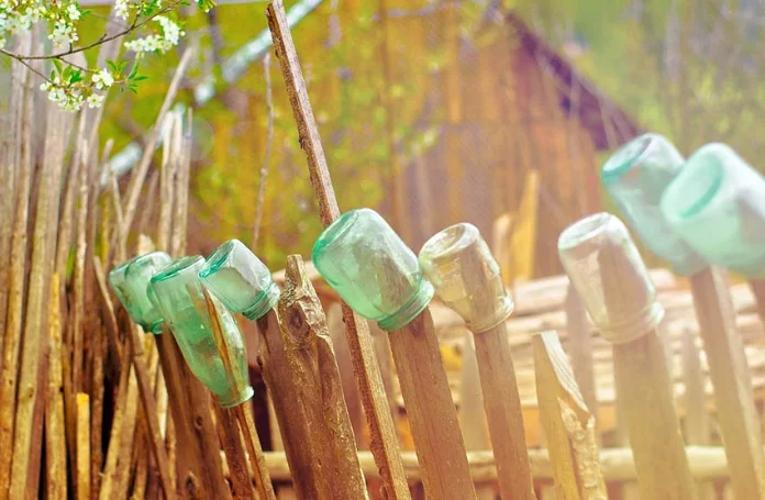 rustic-wood-fence-with-glass-bottles-and-jars.jpg