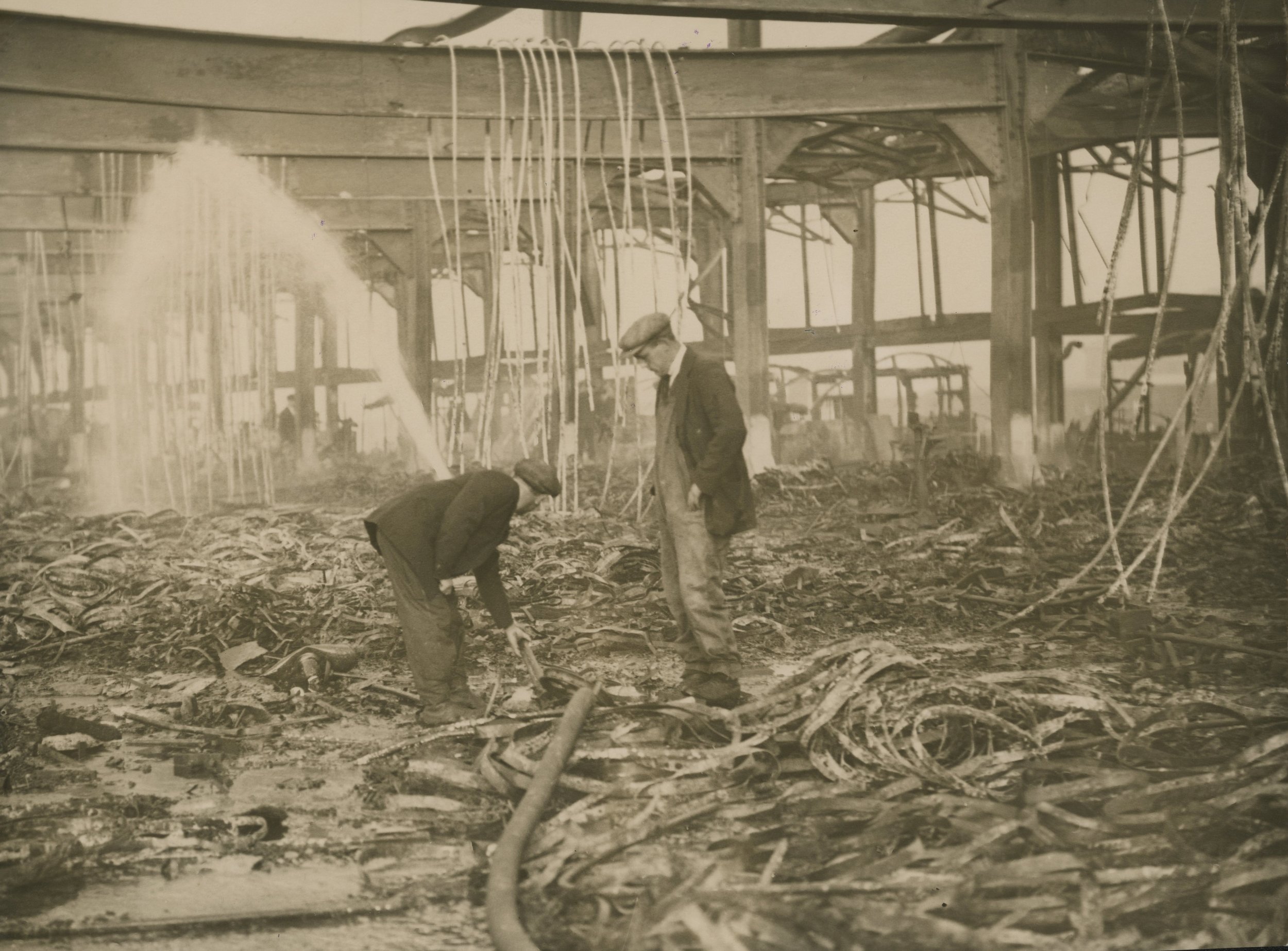 Two men assess the damage done by an air raid. Albert Dock, Hull. March, 1941. Photographer - unknown Commissioned by ABP.