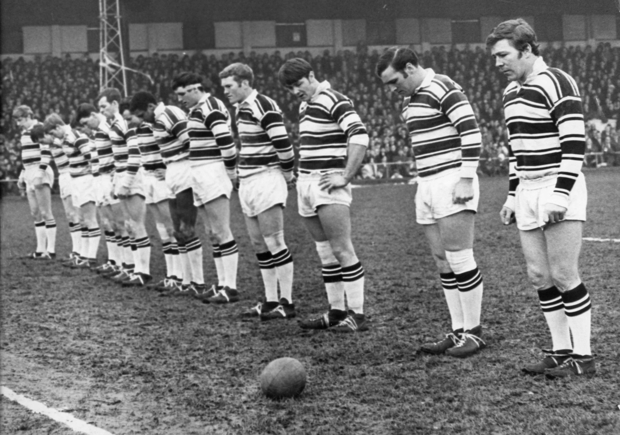 Hull FC players stand in silence before game v Wigan in tribute to Kingston Peridot and St Romanus crews 05-02-1968. Commissioned by Hull Daily Mail.