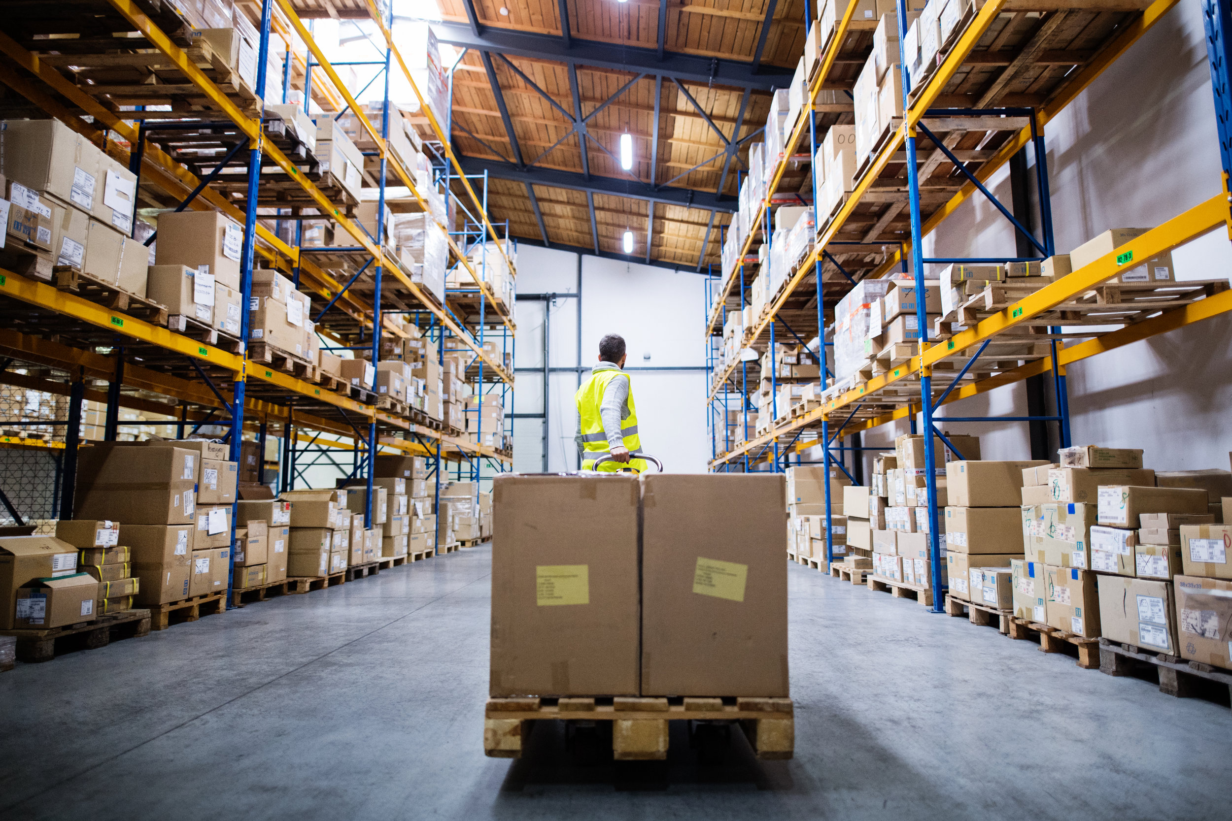 male-warehouse-worker-pulling-a-pallet-truck-PULS6XR.jpg