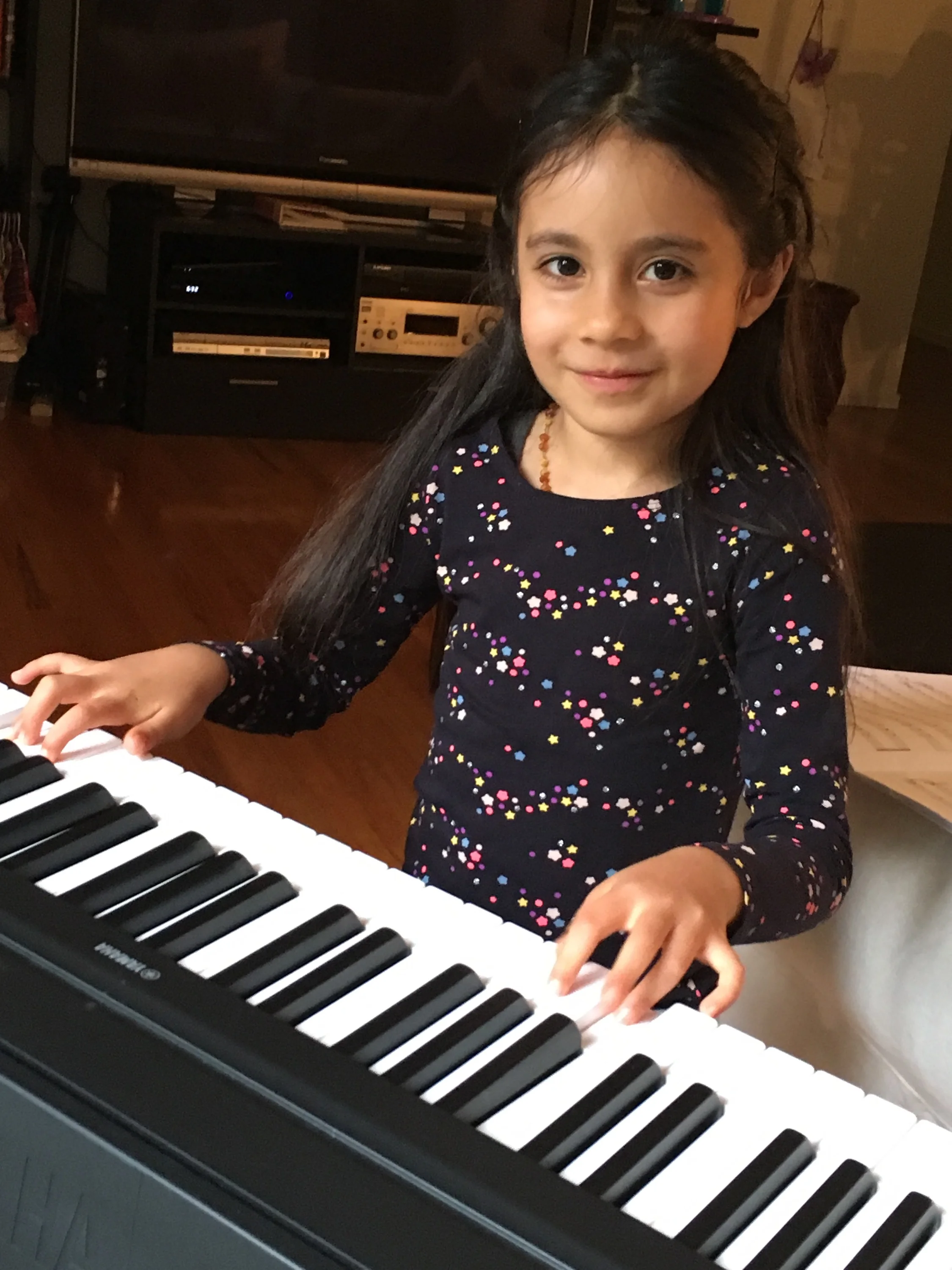 Alessandra practicing piano for her music lesson.