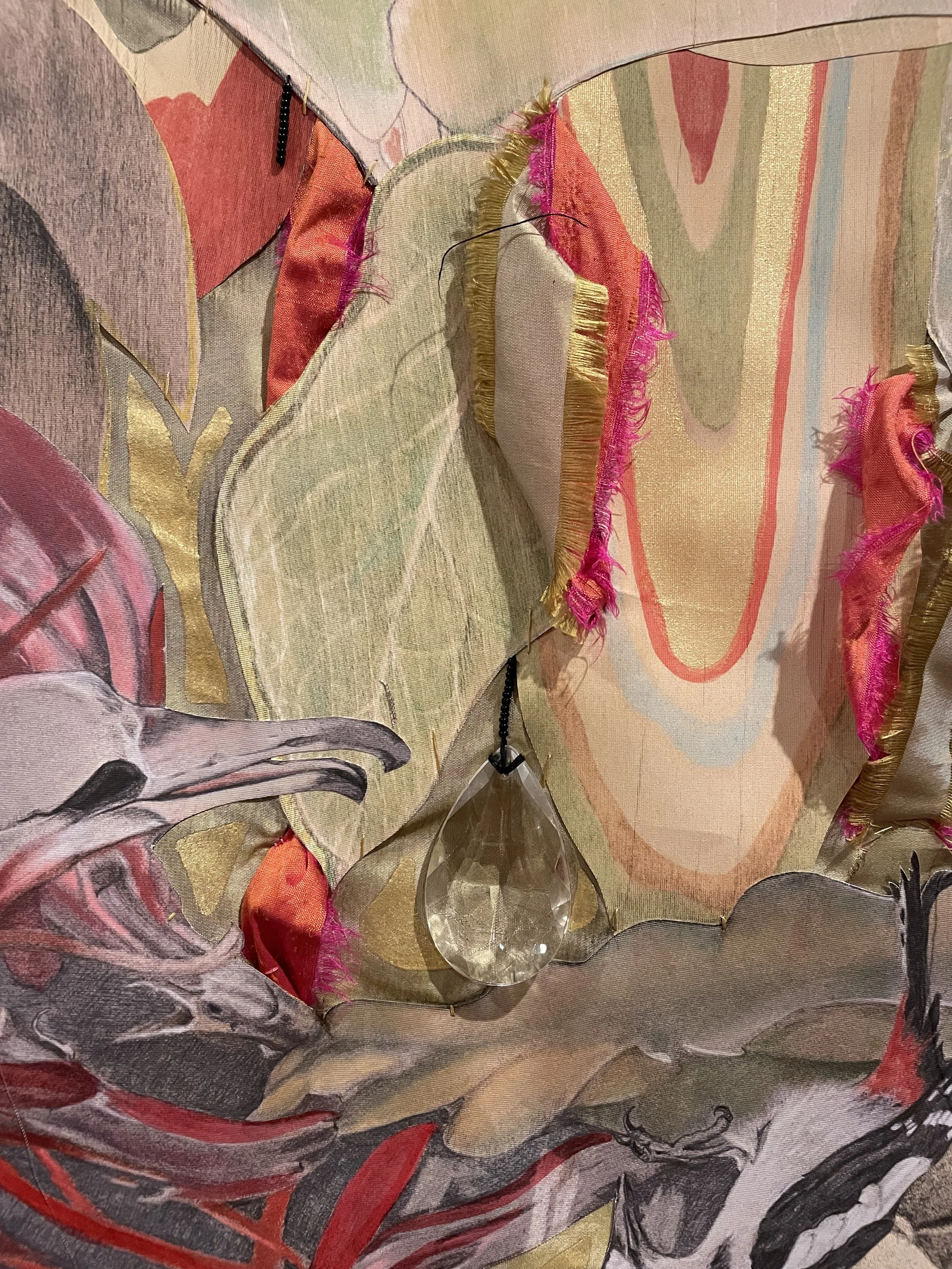 Detail of "The Return" featuring birds, featuring various threads, fabric, and a cut glass teardrop-shaped bead.