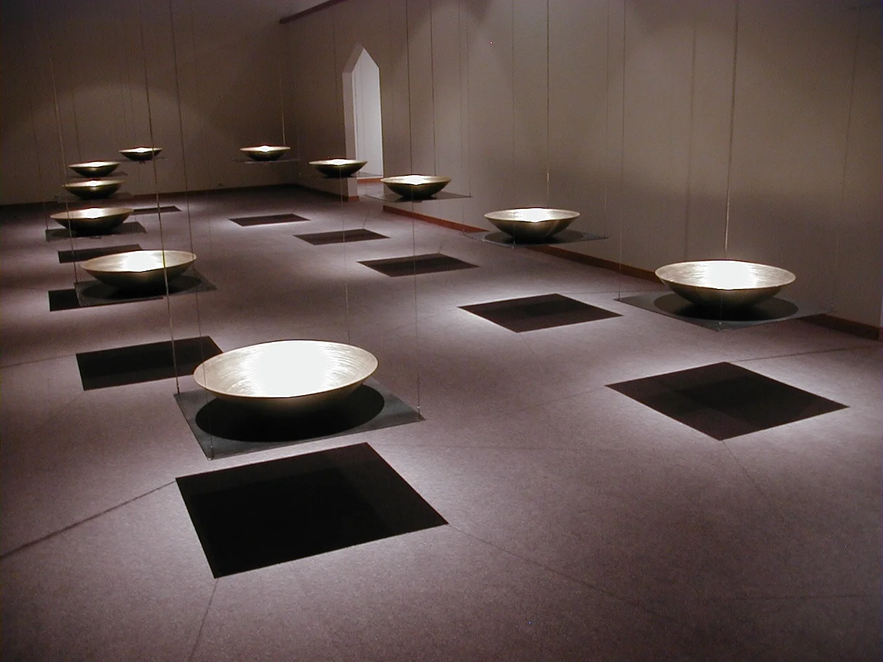 Alchemy (2000). Nicolaysen Art Museum, Casper, WY (Jan. 17 - May 31, 2003). Collaboration with visual artist Christine Wallers. Spun brass, steel, 20 channels of audio. Sound derived from whispering voices of 32 people reading written responses received from over 300 people to our invitation to imagine change in the world. Individual voices are heard through the bowls (via transducers affixed underneath), set on steel plates suspended from the ceiling; the voices morph into increasingly abstract tones as they flow through the space and gradually subside into silence; groups of unprocessed voices heard through small speakers placed throughout the space.