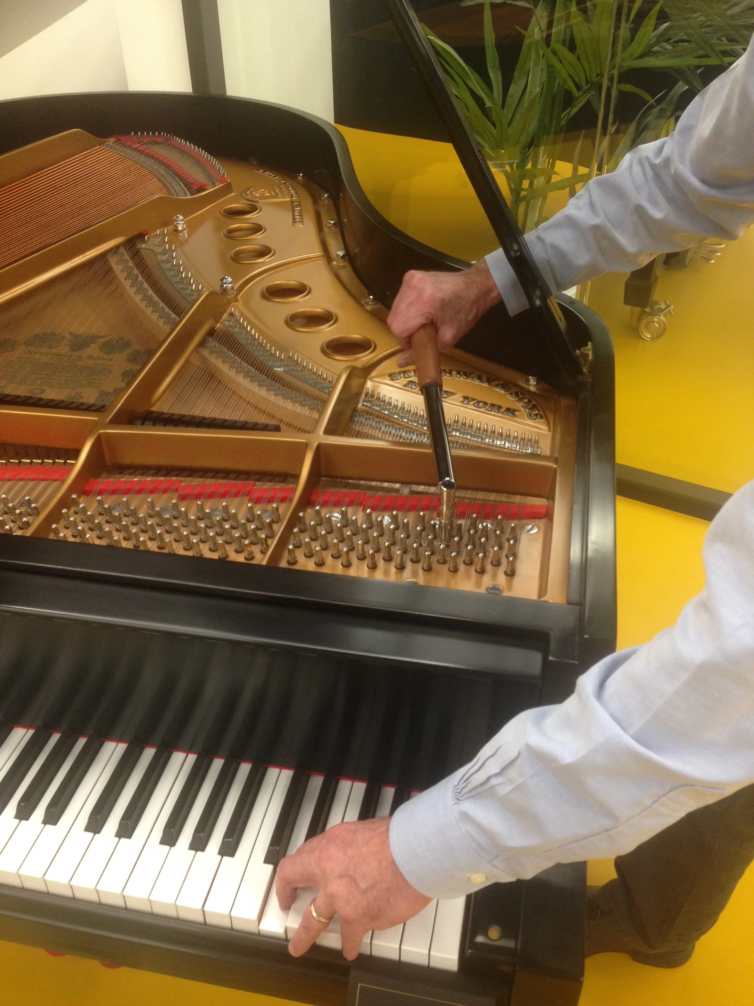 When you tune a grand with an L-lever using your right hand, you have to either work from the side in the high treble...