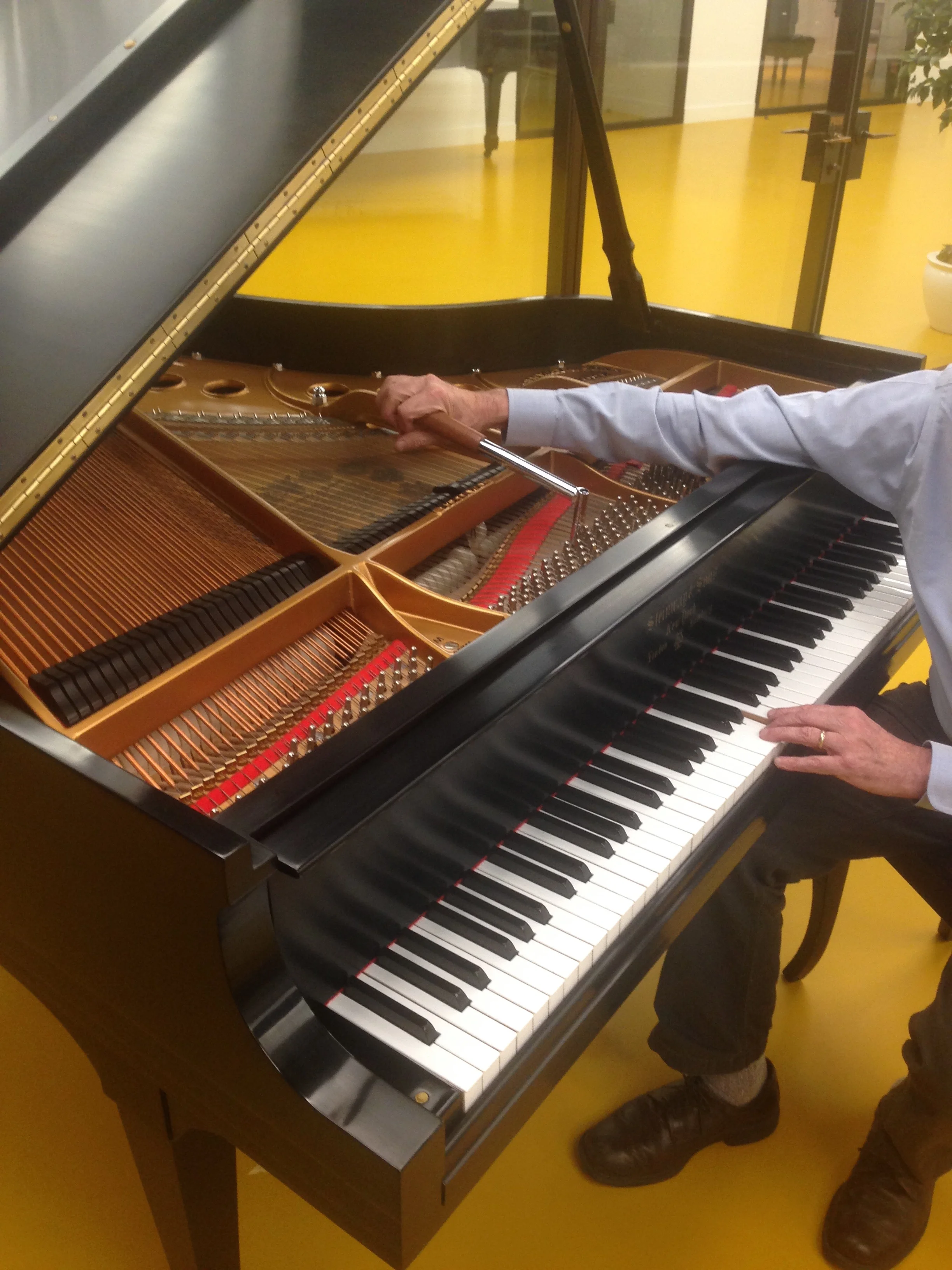 When you tune a grand with an L-lever, your hands are widely separated...