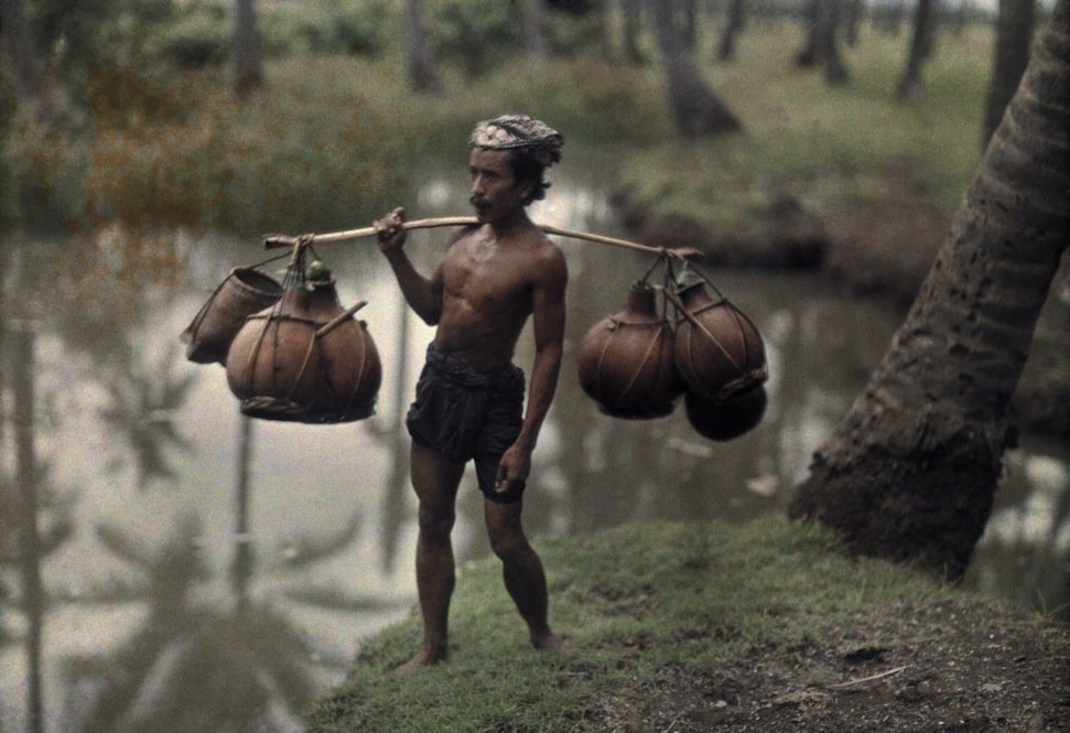 Porter with wine gourds, Bali, 1928