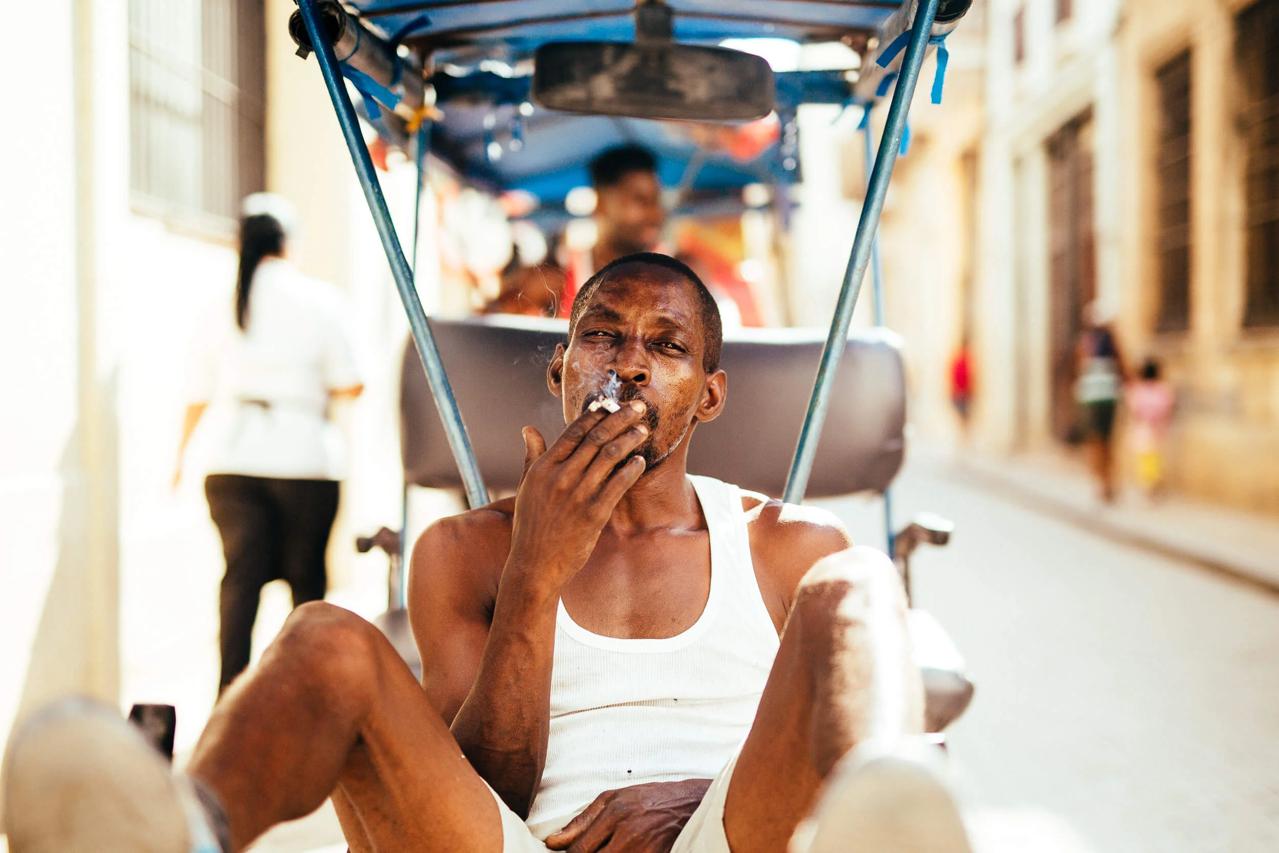 Portrait Cuban bicycle taxi smoking cigarette