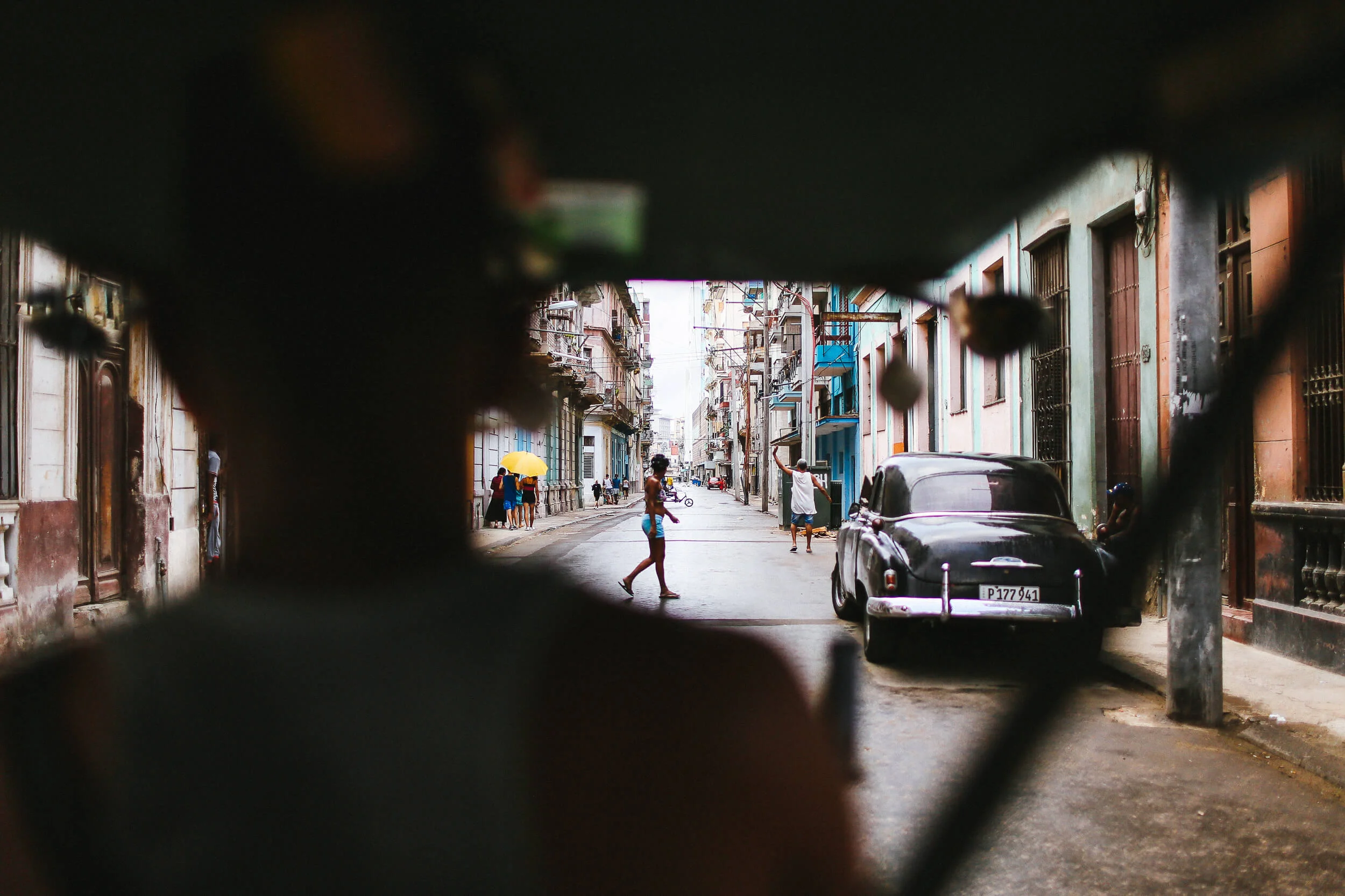 Cuban street from bicycle taxi old car
