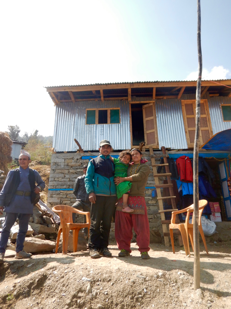 Family in front of house with 2 shops.