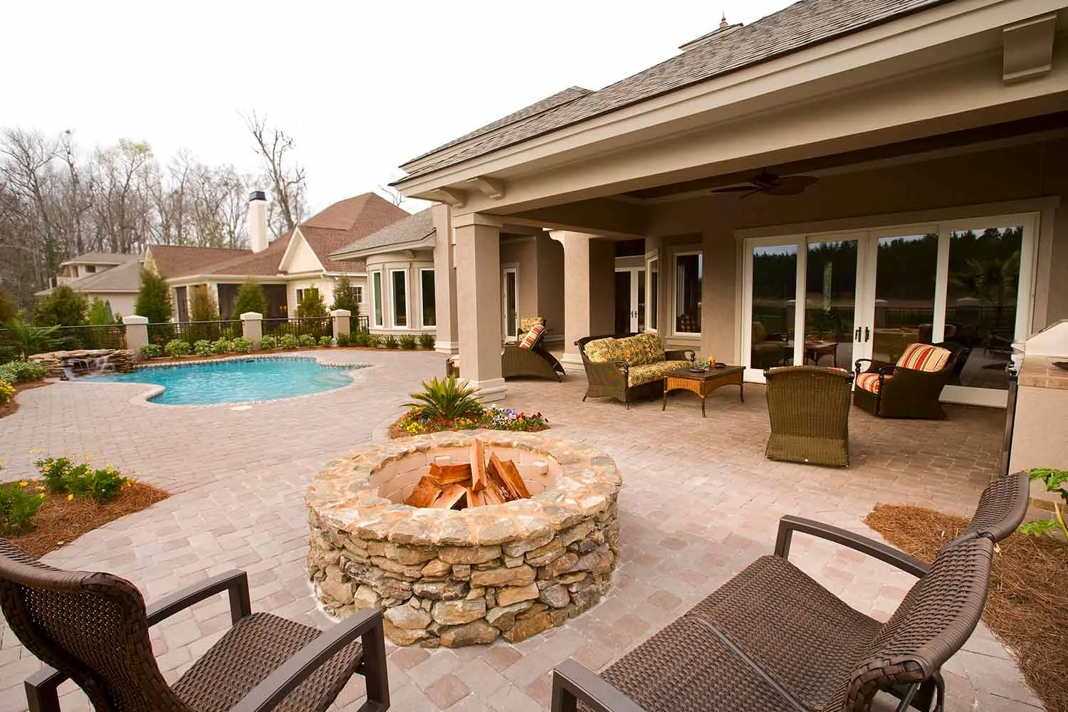 This space demonstrates flow perfectly with several outdoor rooms to enjoy; there's the pool area as well as a shaded conversation area. The firepit zone offers even more to enjoy- it's the perfect space for entertaining!