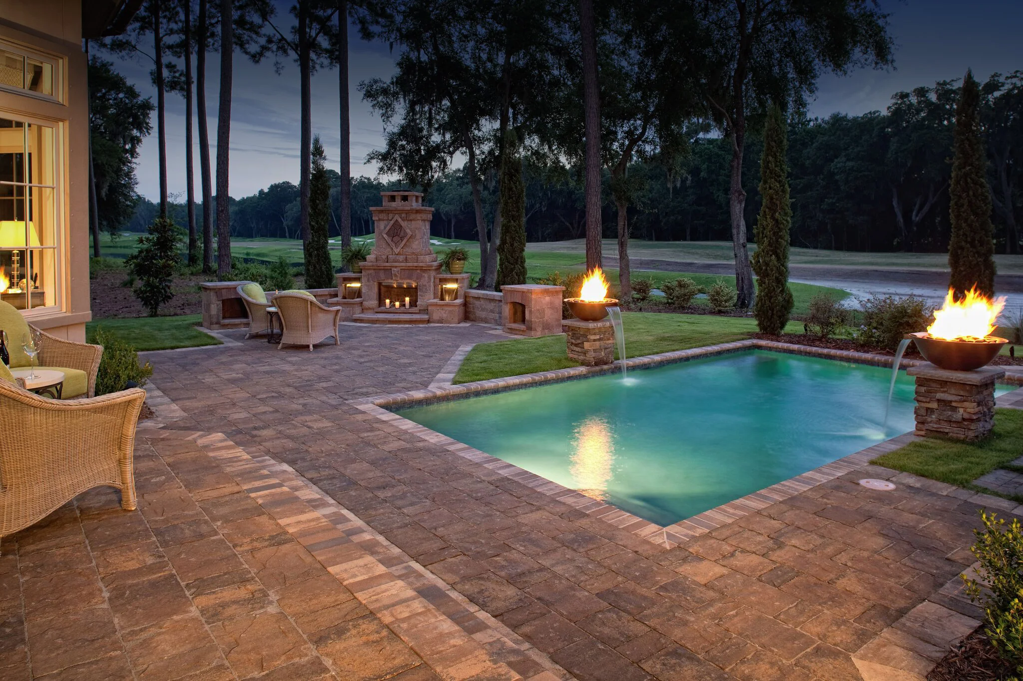 The warm paver design for both the patio and pool deck of this home allows the design to easily flow from one outdoor space to the next. We offer a variety of copings and cap units that can be used for trim. If you look closely at the project above you'll notice we used the same trim for the steps and around the landscape to create a final polished, cohesive look.