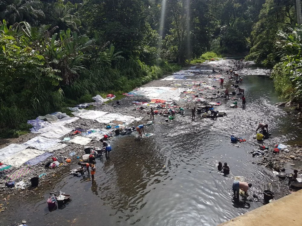 Women washing clothes in a stream at Sao Tome