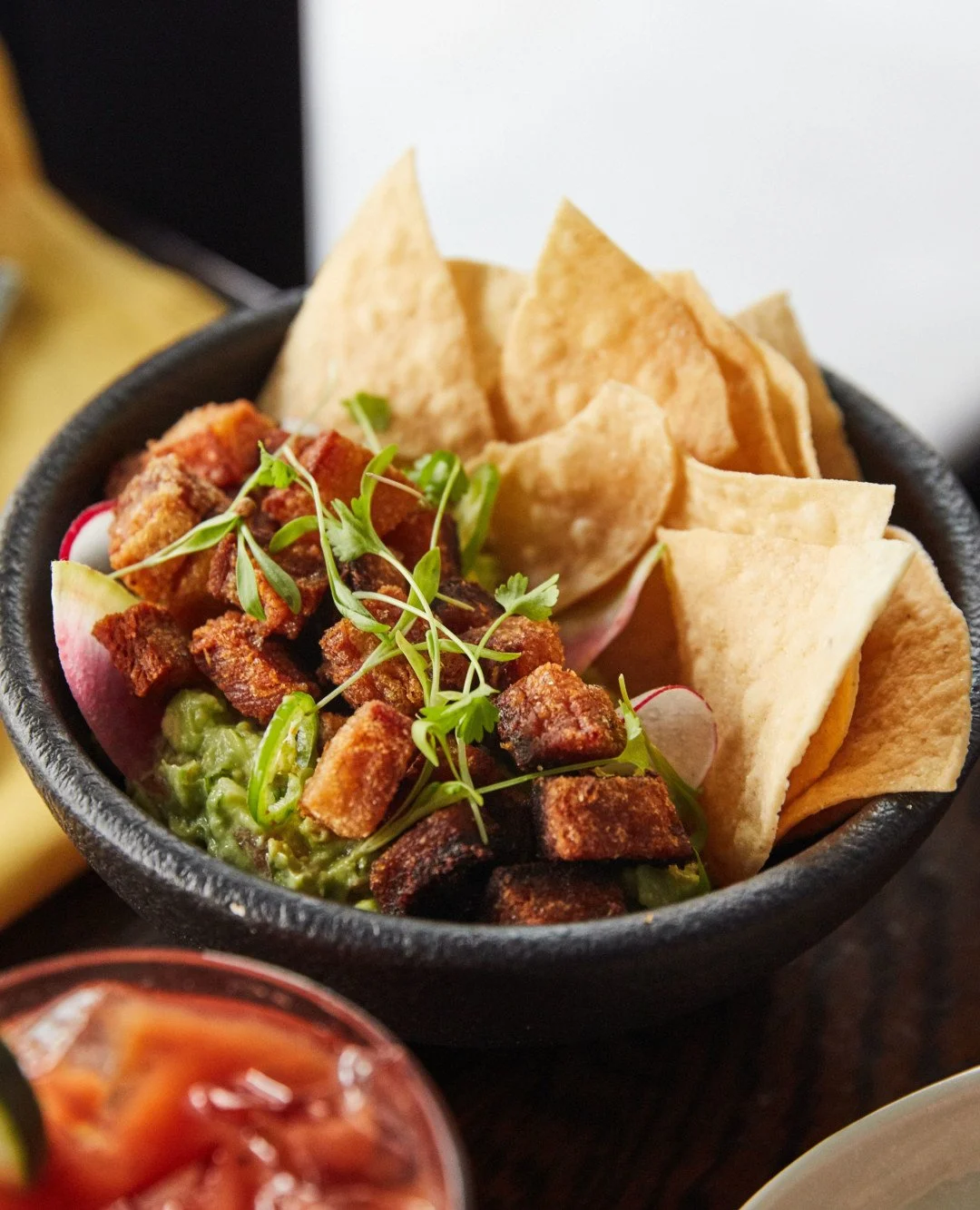 Warning: this chicharr&oacute;n is dangerously crispy, topped with cheese cotija, pickled chili, and fresh radish for that perfect bite.