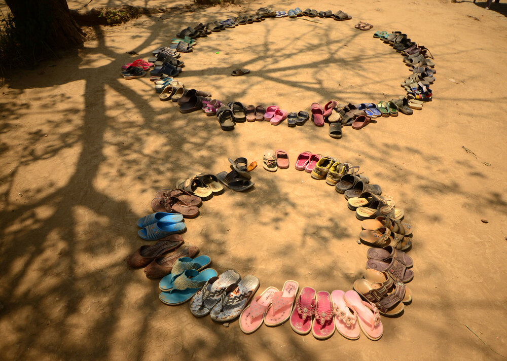 Shoes arranged outside informal school. Click the photo to expand.