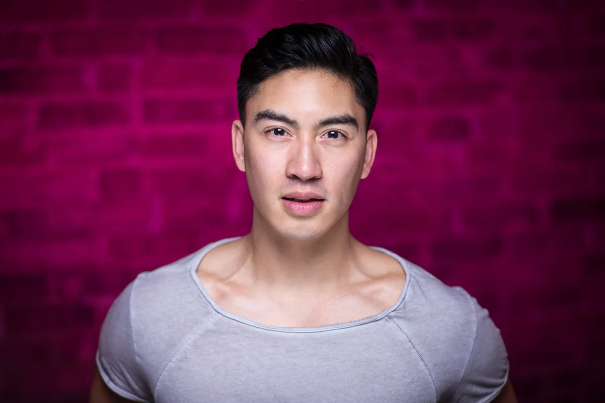 A strong headshot of energetic actor Devin Ilaw - hot pink blast