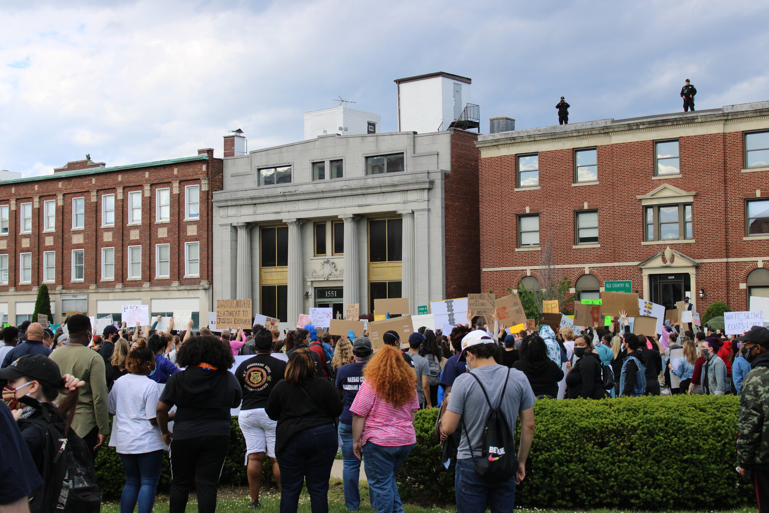  Long Island residents gathered to protest in Mineola, New York as guards watched from the top of a building.  Photo by: Brandon Allen    