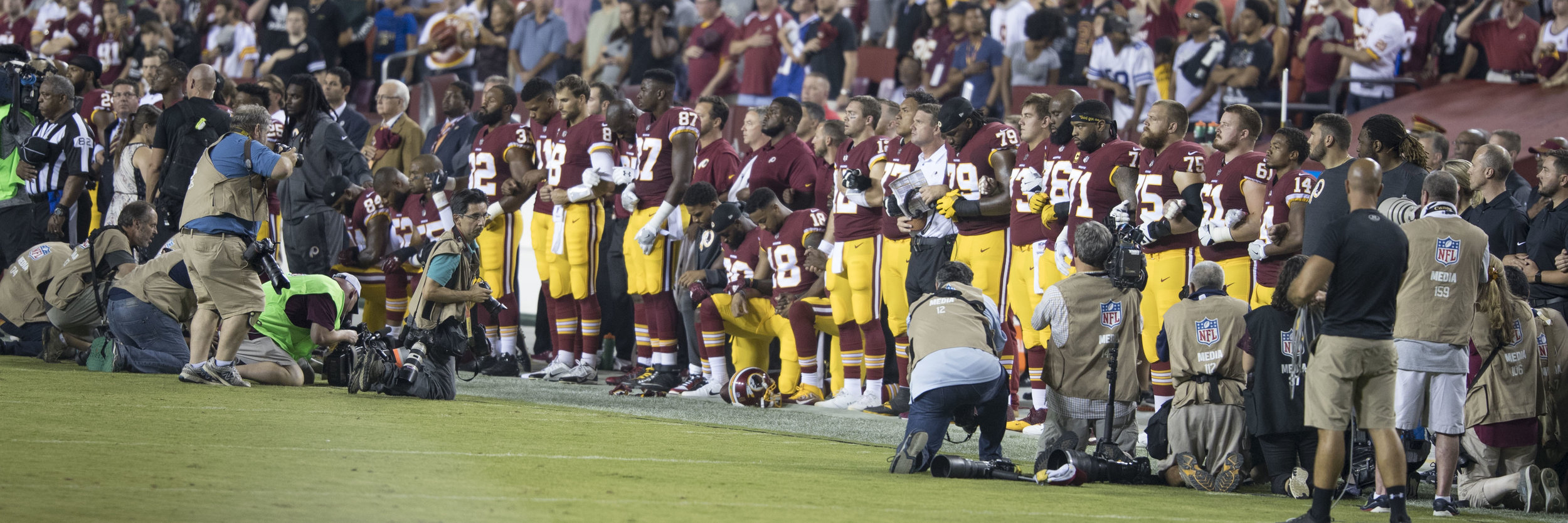 Members of the Washington Redskins kneel during national anthem before football game. Photo courtesy of Wikimedia Commons.