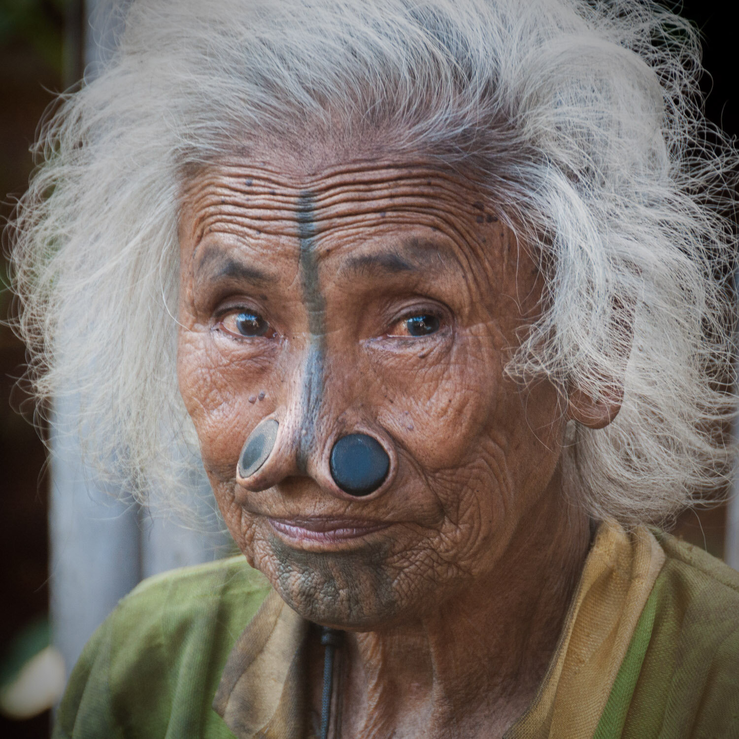 Api Tani woman with facial tattoo and nose plugs