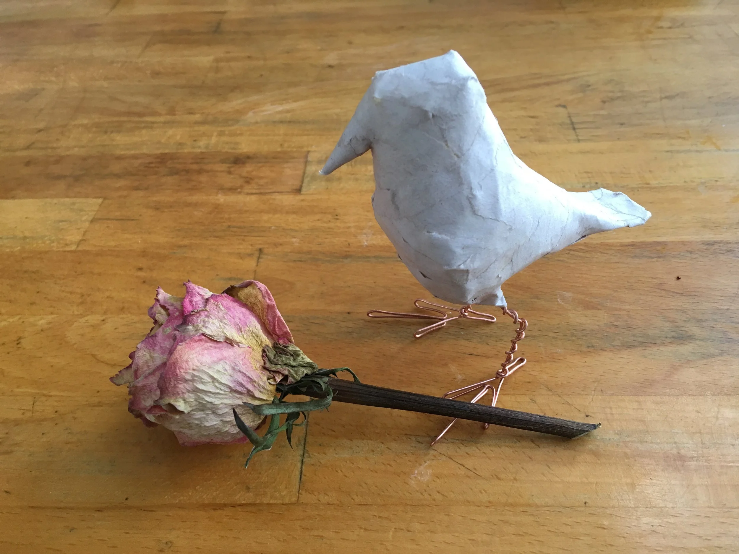 Bird armature contemplating potential rose covering