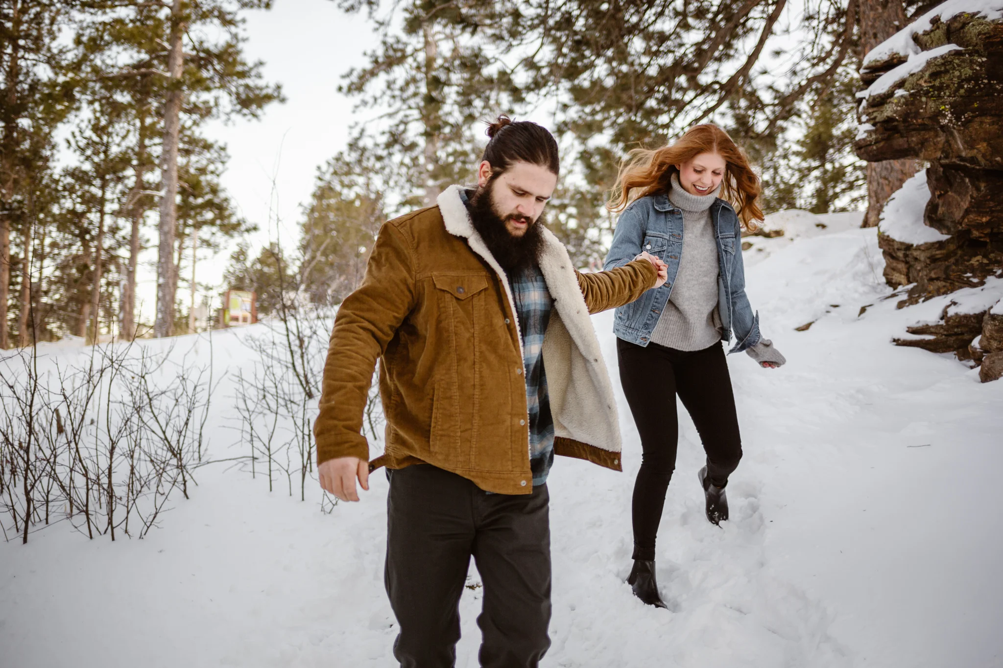 couple walking in snow engagement photos