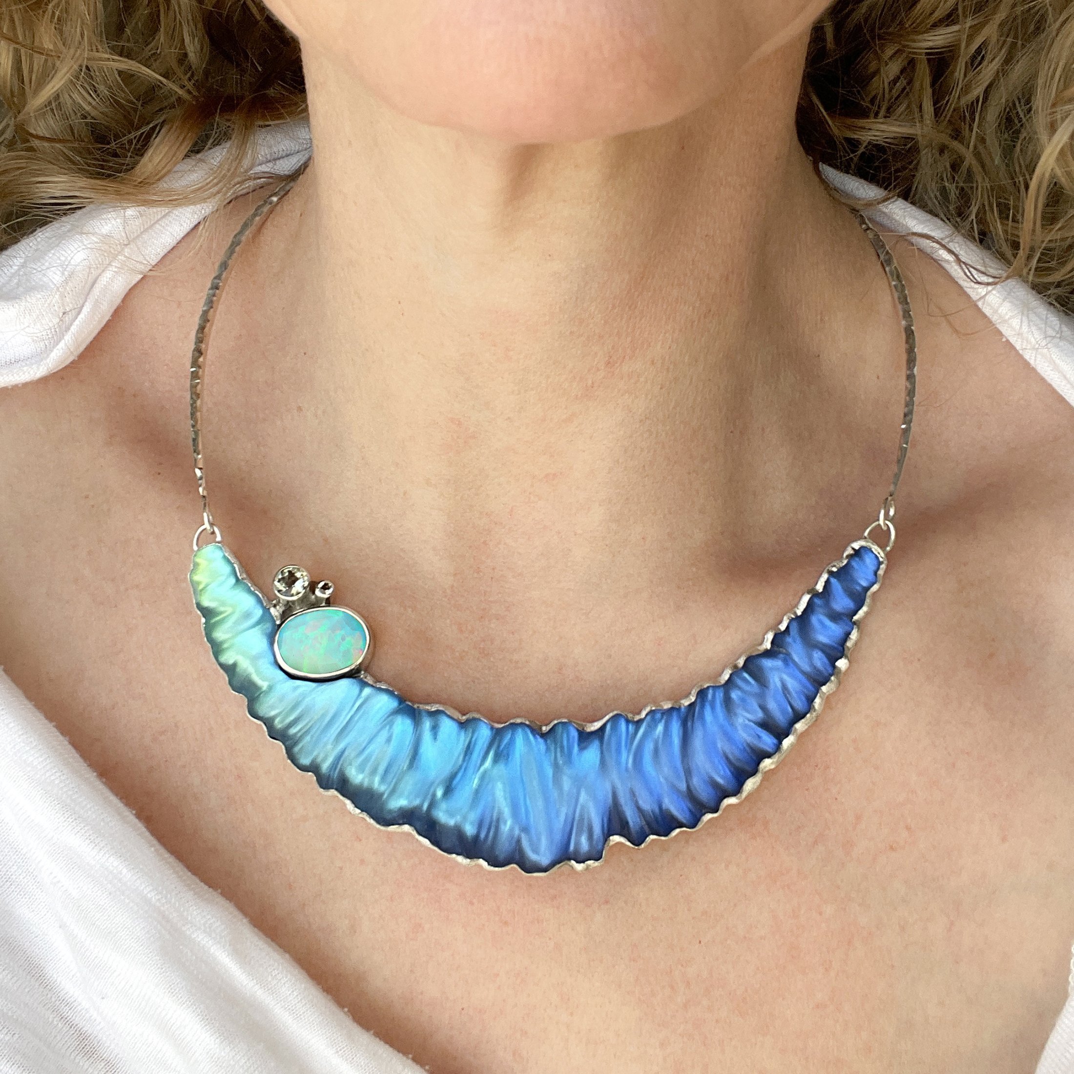 A model wearing an ocean-inspired statement glass and gemstone necklace made by Debra ADelson