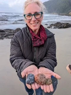 Artist Debra ADelson holding volcanic rocks she found on an Oregon beach while rock hunting.