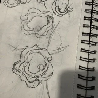 Sketchbook page of looping, concentric pencil drawings with a spiral binding.