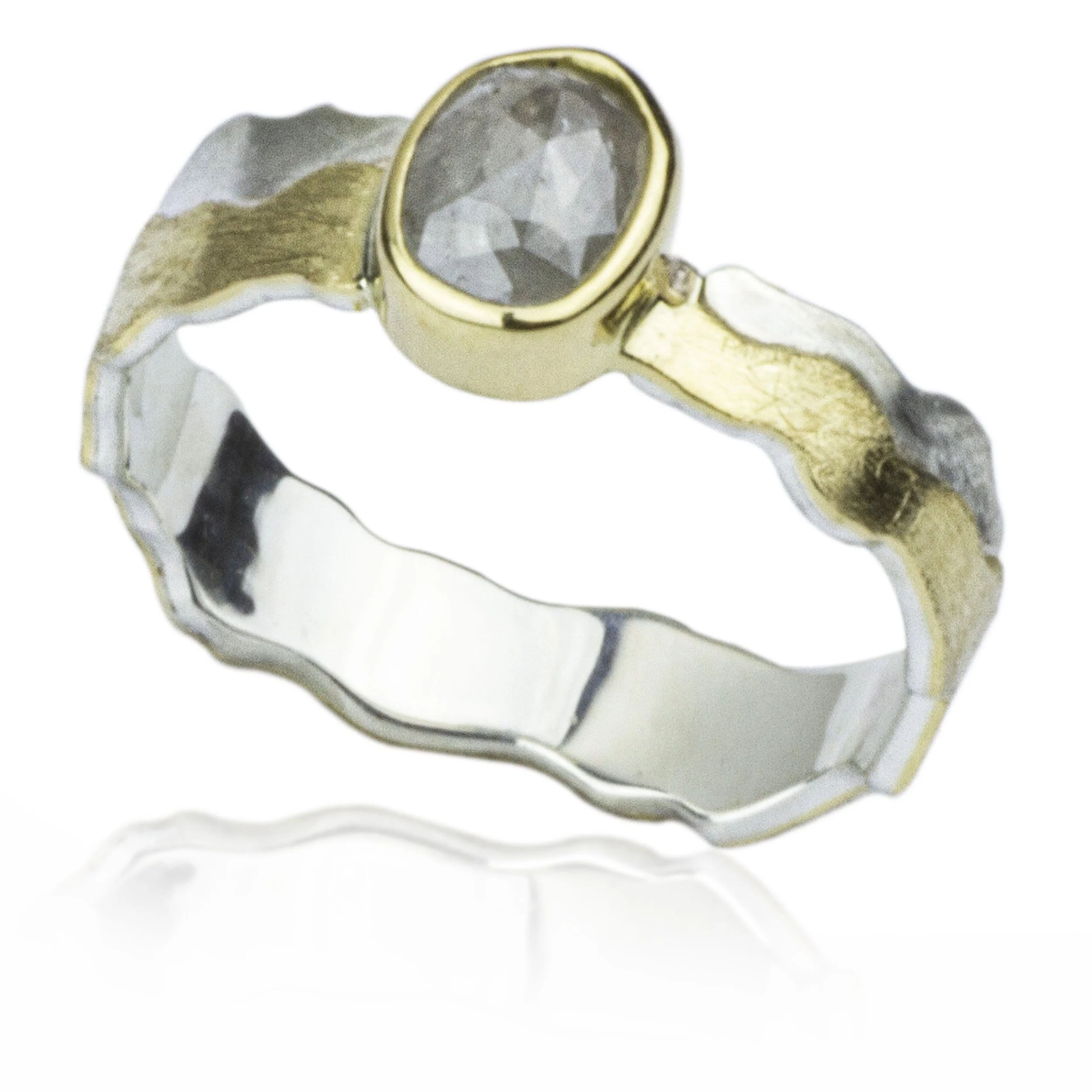 An 18k gols and serling silver solitaire rings with a natural rose cut salt and pepper diamond.