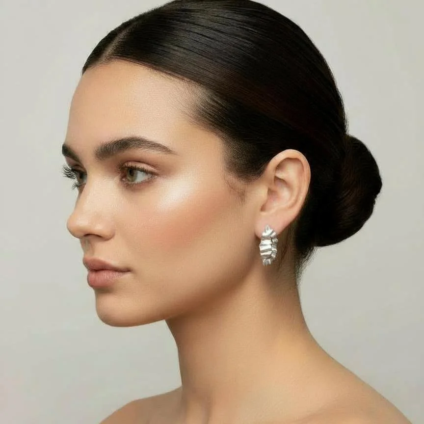 A model wearing a pair of handmade sterling silver earrings.