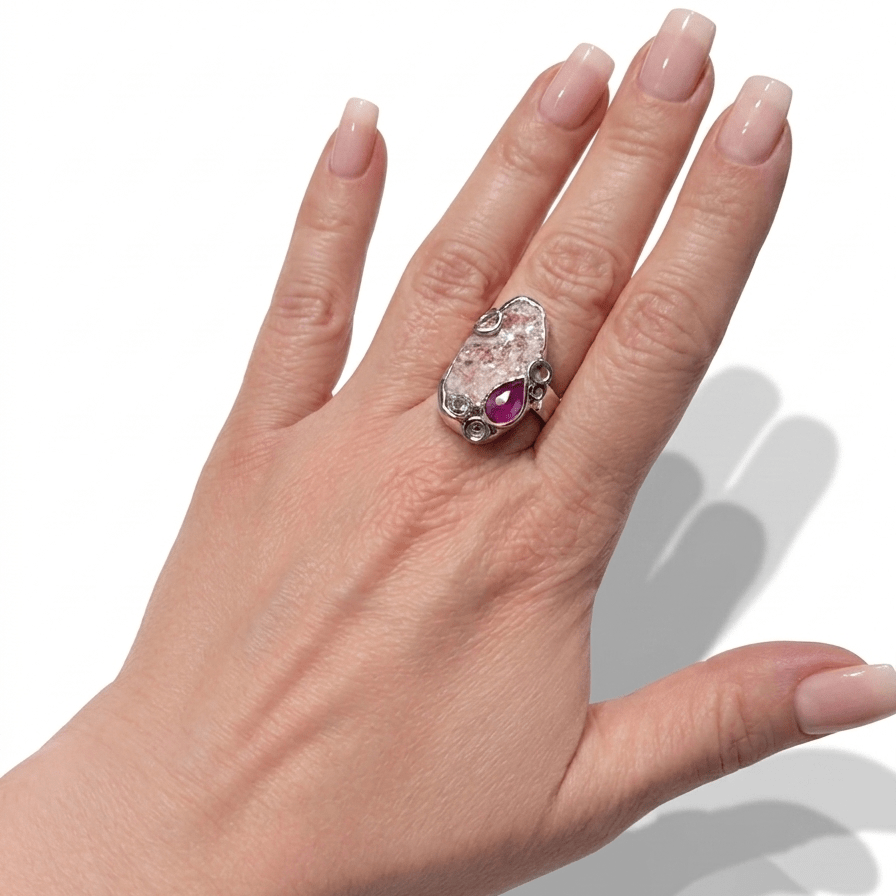 pink-champagne-laying-down-muscovite-topaz-sapphire-on-model-hand-web.png