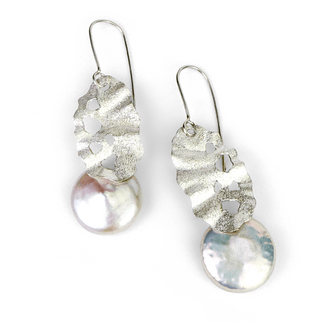 Sculptural sterling silver earrings with pierced texture and round freshwater pearl drops.
