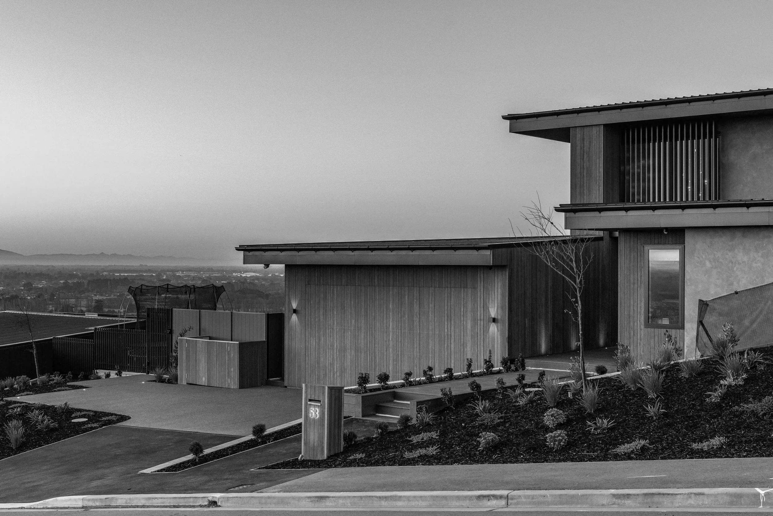 KENNEDYS BUSY ARCHITECTURLA HOME O NTHE HILL WITH WOODEN CLADDING AND HIGH END FINISHES WITH VIEW OVER CHRISTCHURCH AND HILLS