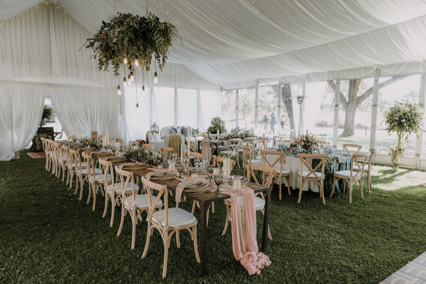 Beautiful drapped tent with long boho barn inspired table decor and floral chandelier.