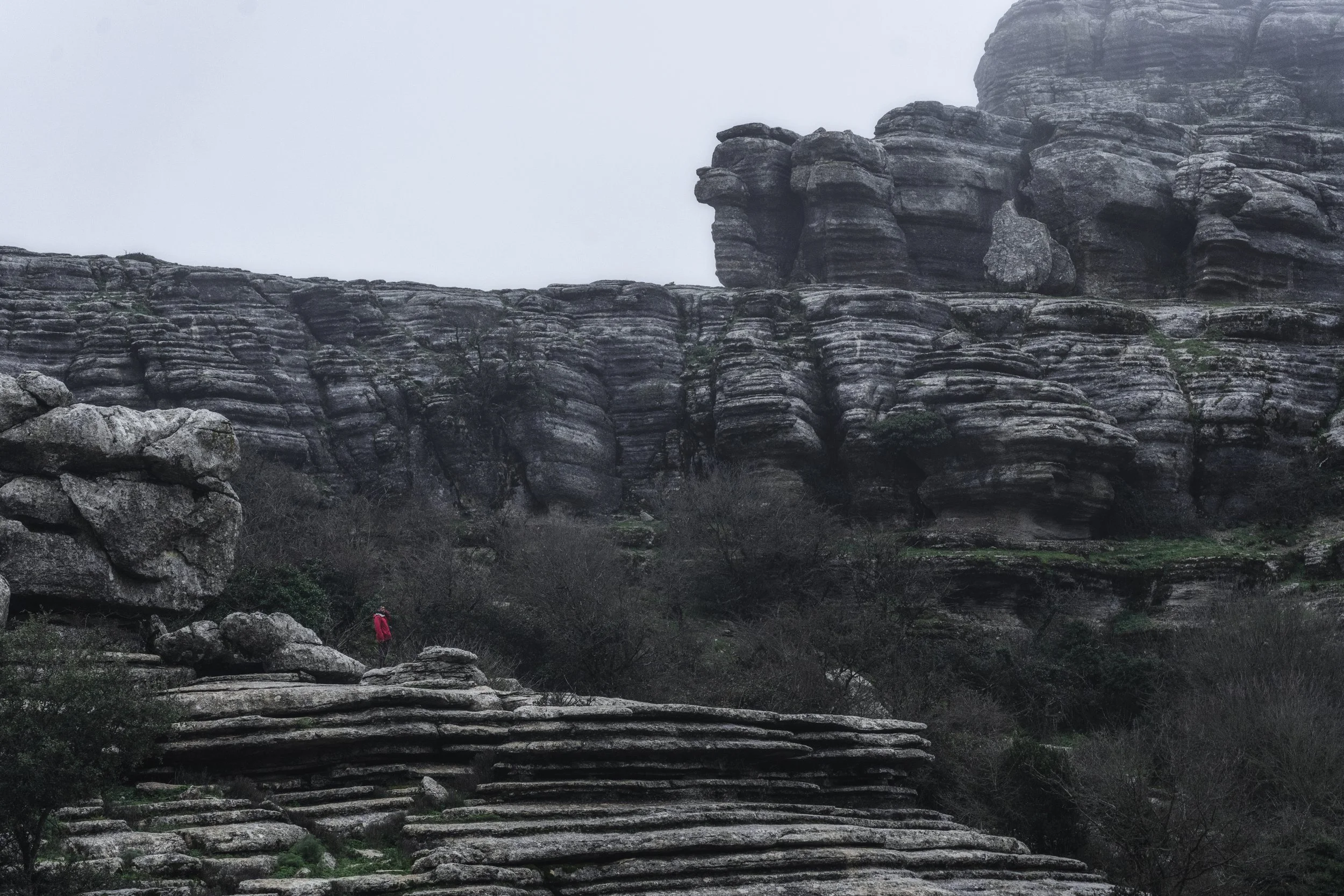 Person stands on rocky outcrop overlooking El Torcal landscape