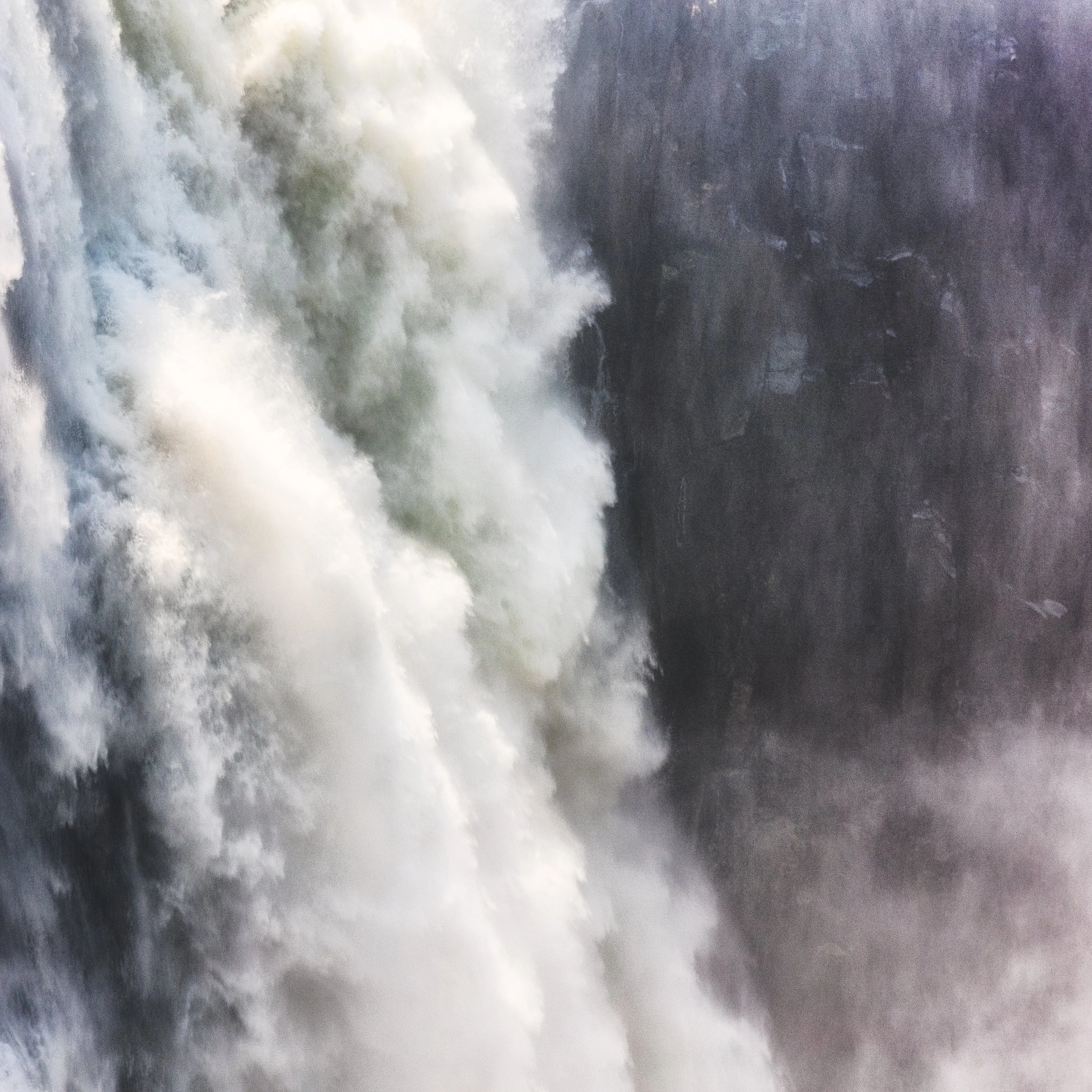 Close-up of a powerful waterfall with white water crashing down over rocks.