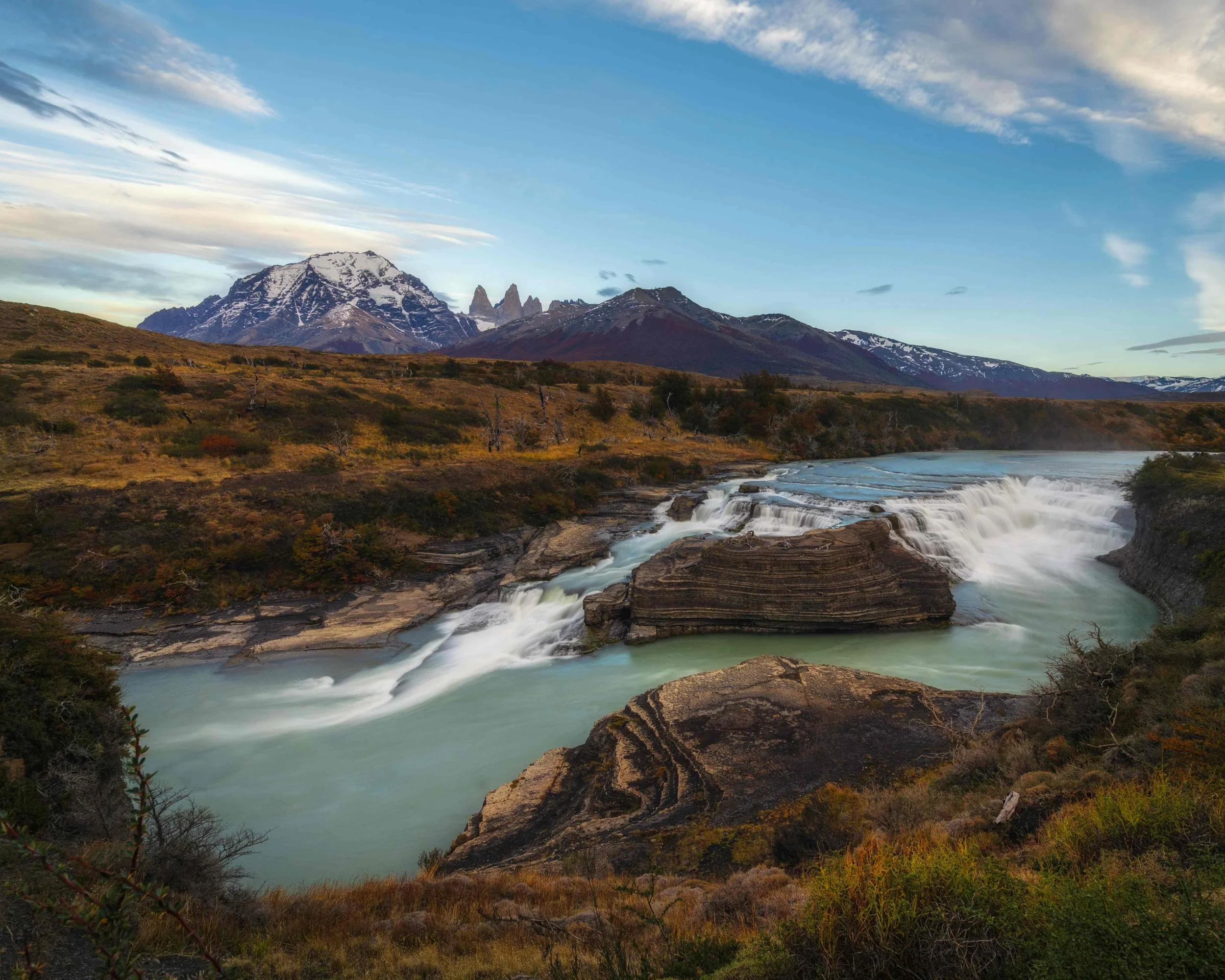 Waterfall at the base of the mountains range Torres Del Paine