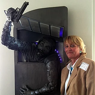 Heather Davis with her sculpture called “Shadow Man,” which depicts Mitch Rapp escaping into an open from a return duct. This sculpture won “Best of Show” -the award of excellence by the people’s choice at Chester County (PA) Art Association Show at the Chester County Gallery last December. She gifted this piece to Vince.