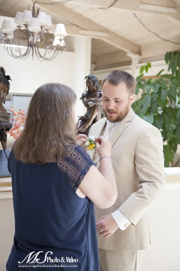 Grooms mother starts putting on the corsage
