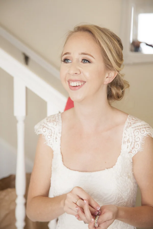 The bride is smiling by the side of the camera