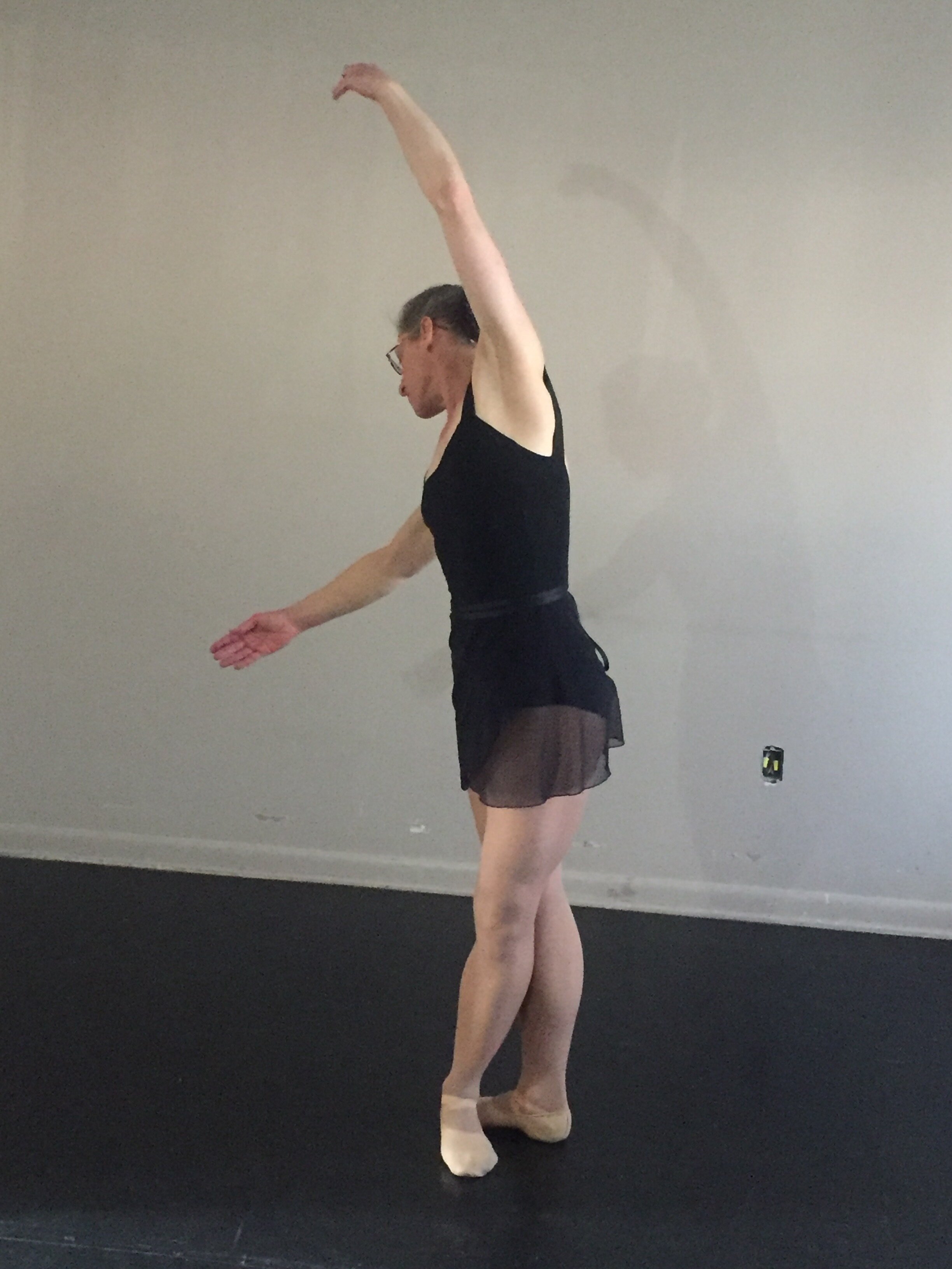 Dancer bends at the waist over the upstage shoulder