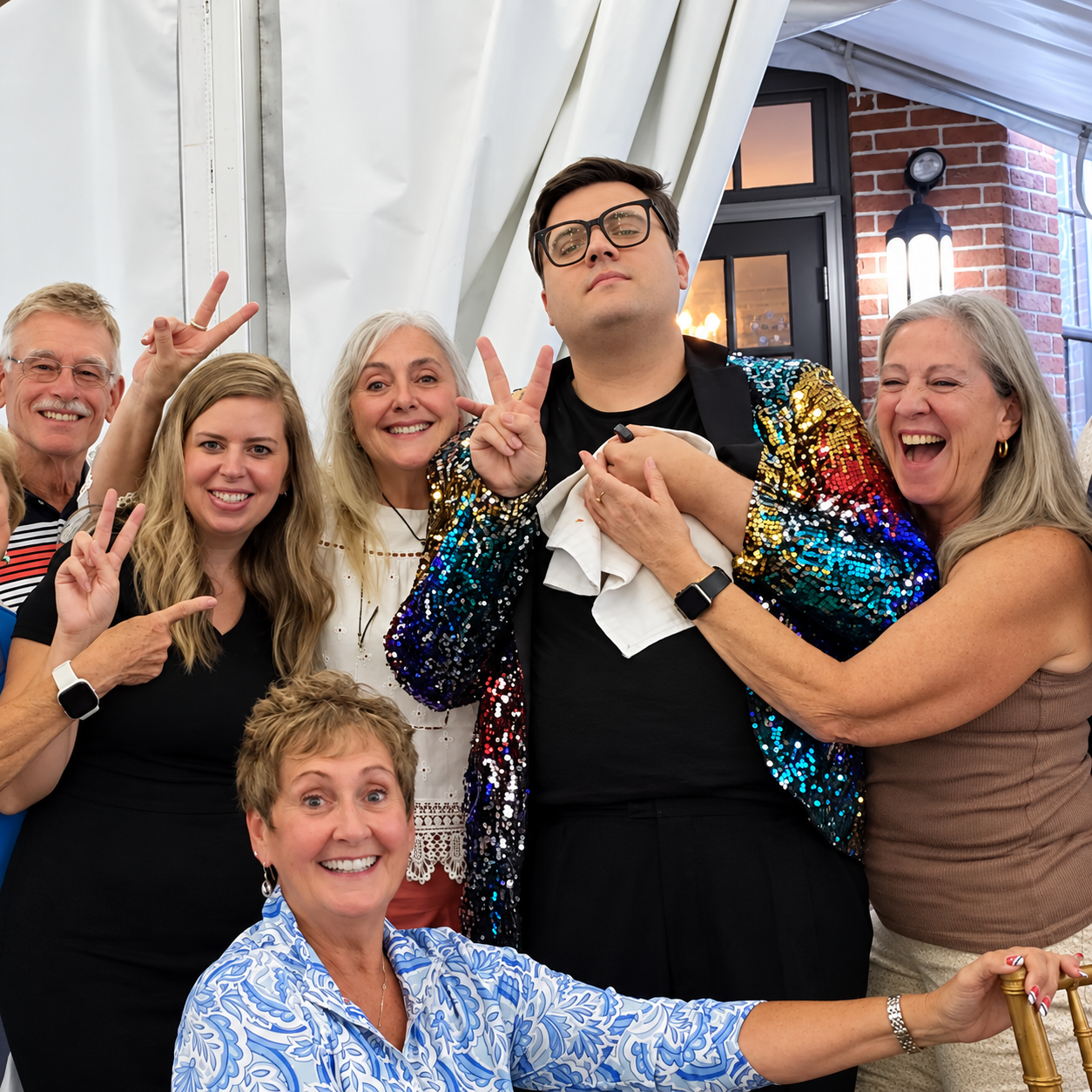 Guests smiling and posing together during a festive murder mystery party event.