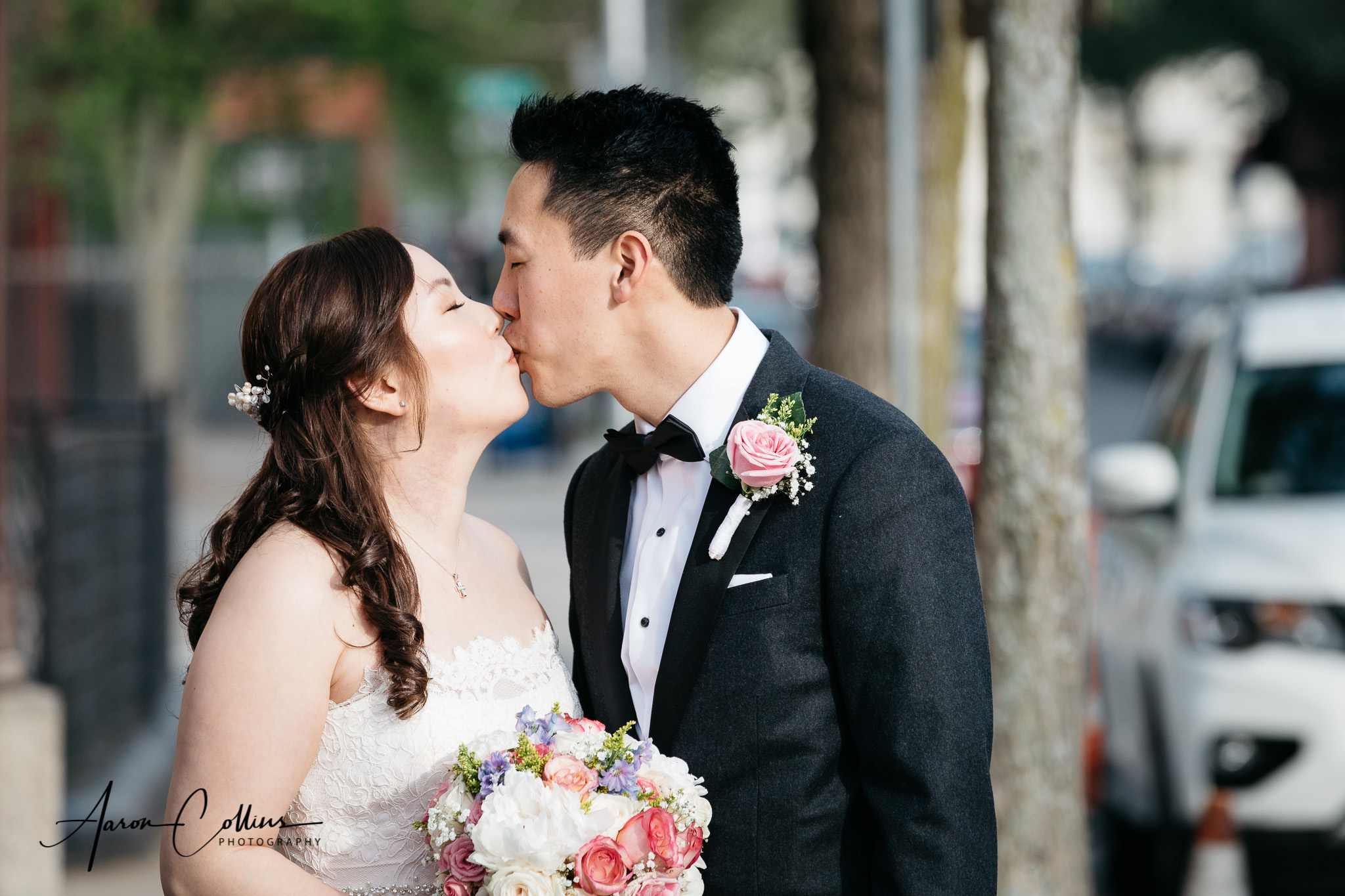 Bride and groom share a kiss on the street in cambridge