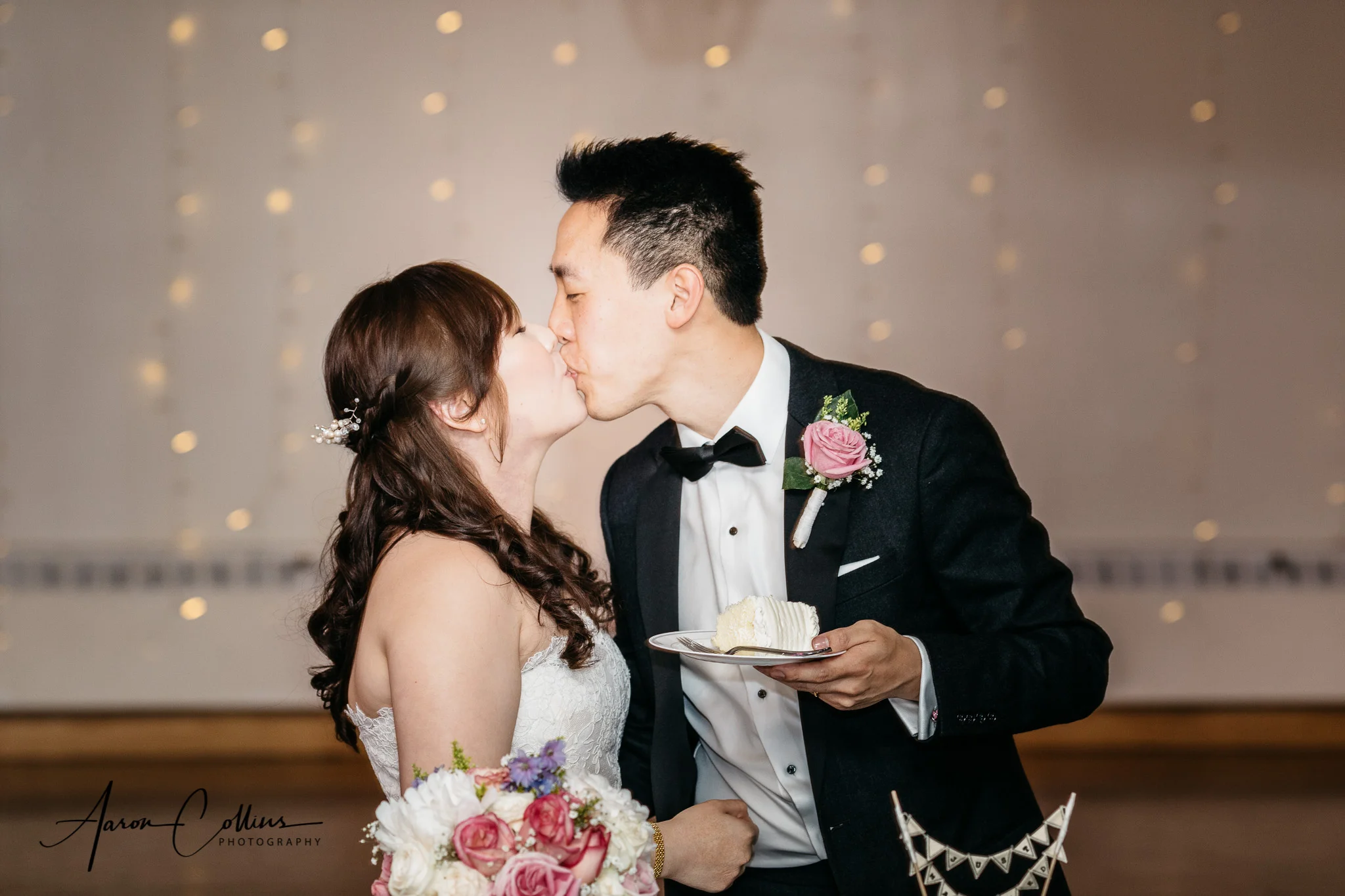 Bride and groom cutting the cake and sharing a kiss
